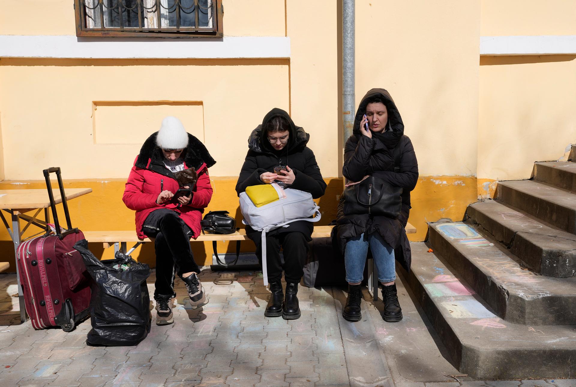 Three women displaced by the Russian invasion of Ukraine check their mobile phones at a refugee centre in Hungary. 