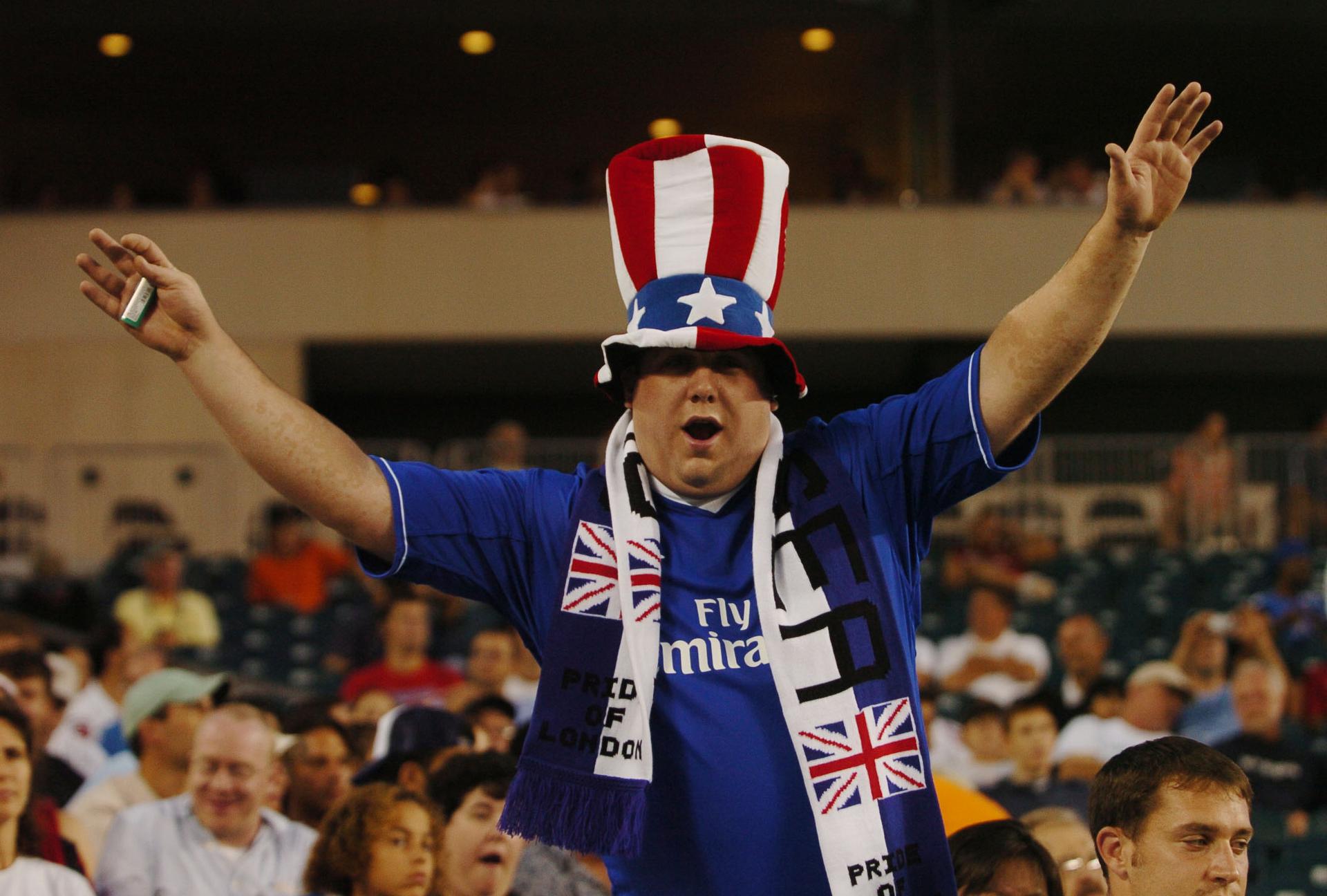 A cheering football fan in a loud hat with American colors