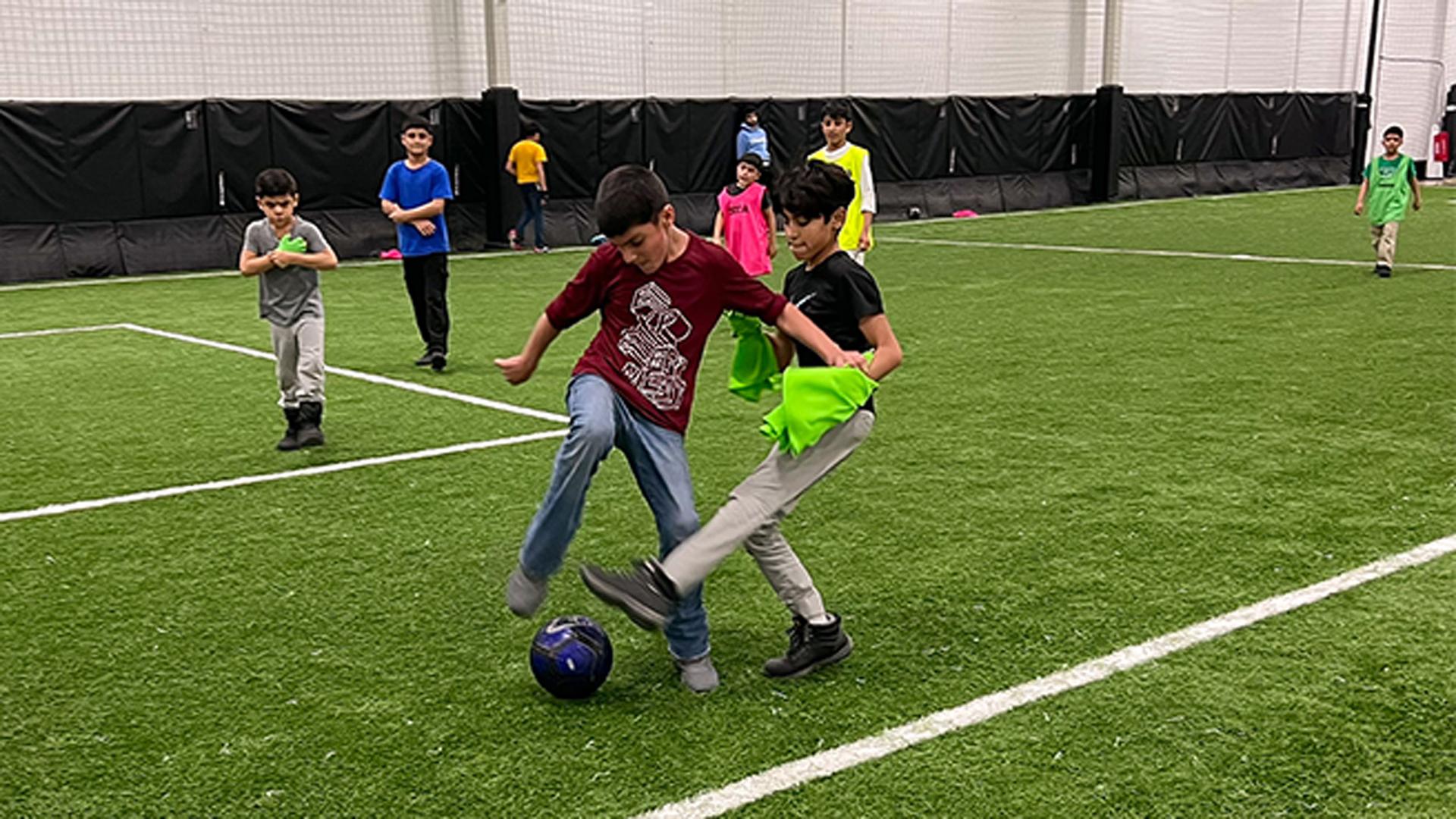 Some of the younger boys of newly arrived Afghan refugees play in their own game at a St. Louis sports facility. The weekly get-together is a chance to exercise and make new friends.