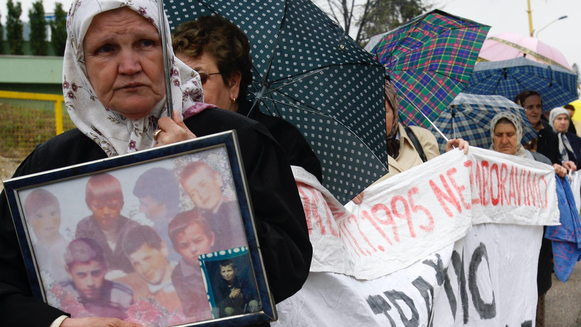 Bosnian Muslim women, and survivors of the Srebrenica massacre carry photos of relatives and display a banner with names of missing relatives, during a peaceful protest walk, in Tuzla, 72 kilometers north of Bosnian capital of Sarajevo, April 12, 2010. Su