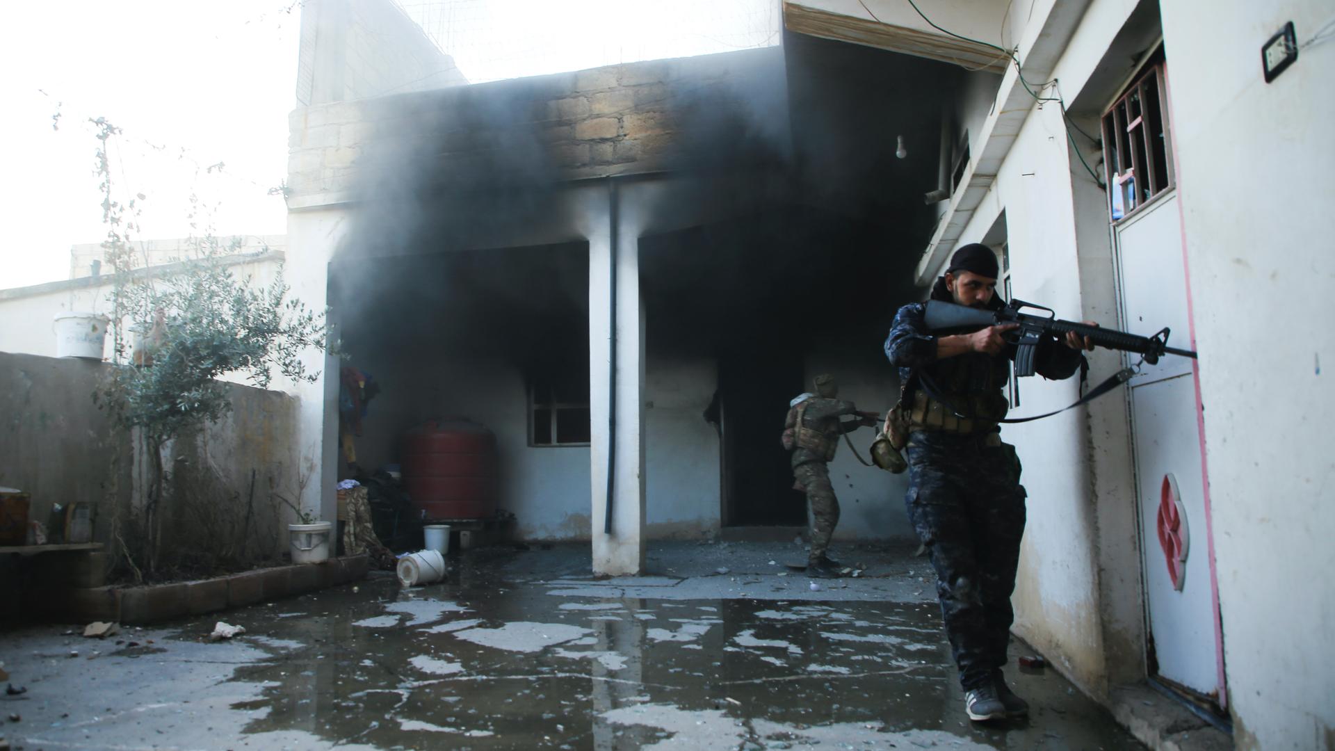 Soldiers with the US-backed Syrian Democratic Forces check a house in Hassakeh, Syria, Jan. 25, 2022. After breaking into the prison late Thursday, ISIS militants were joined by others rioting inside the facility that housed over 3,000 inmates, including 