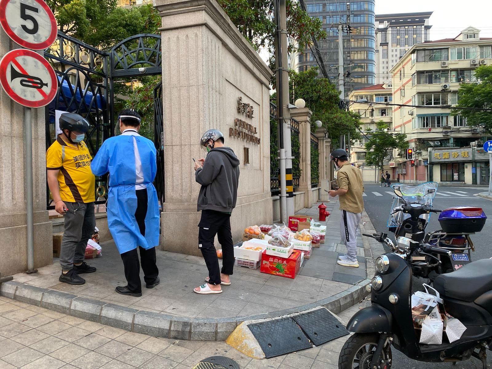 Couriers drop off packages at a gate in Shanghai, China.