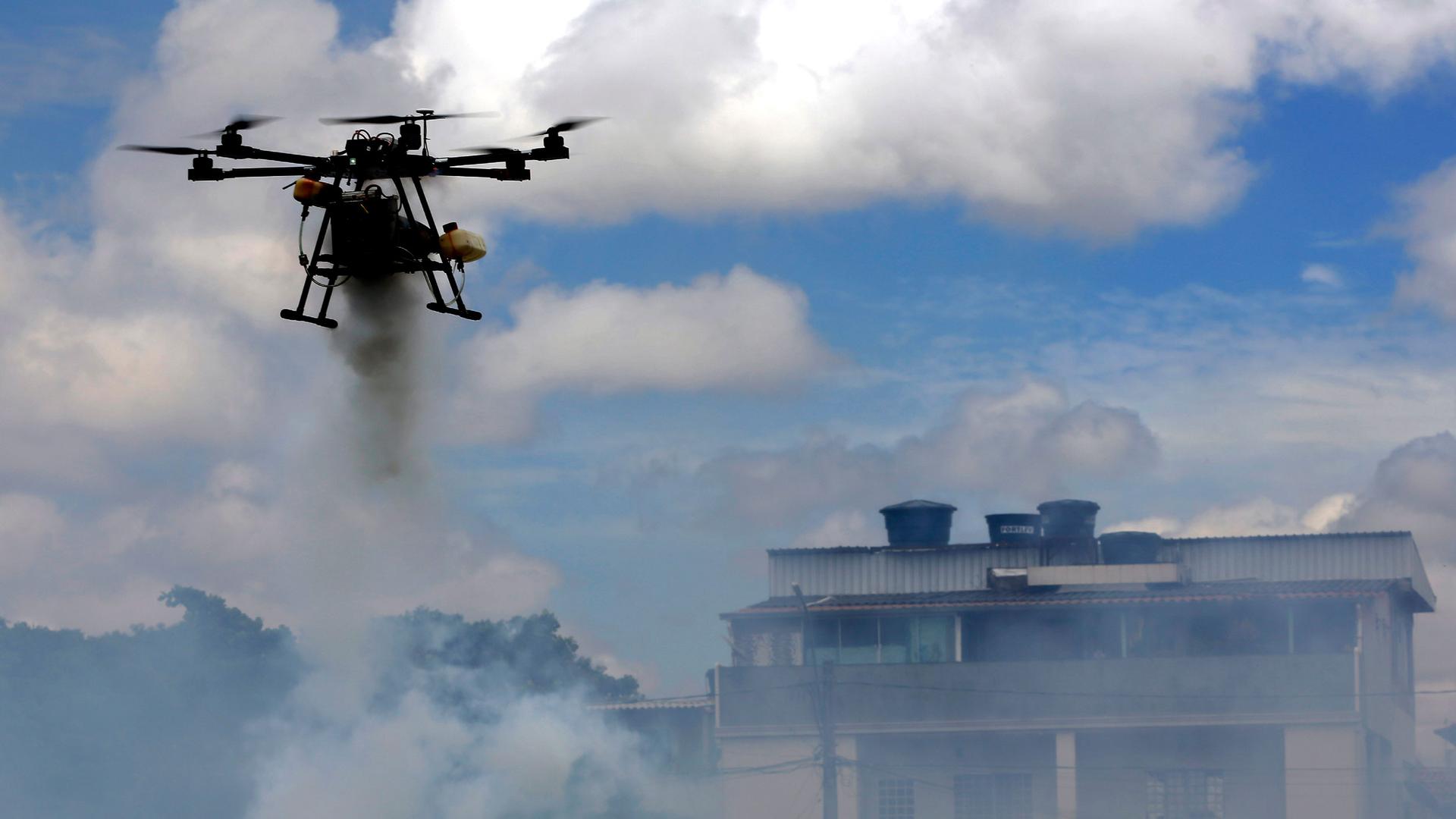 A drone sprays insecticide near homes on the outskirts of Brasilia, Brazil, Tuesday, Nov. 24, 2020. Brazil's health ministry launched a campaign to fight the Aedes aegypti mosquito, which transmits dengue, zika and chikungunya, diseases that can generate 