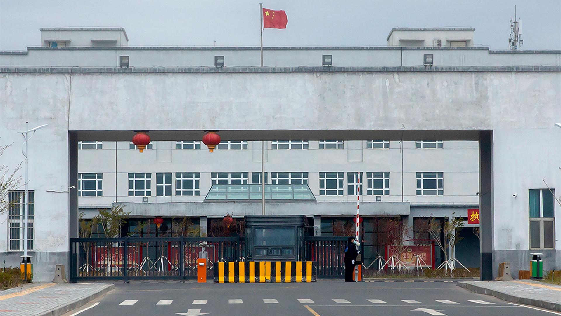 Police officers stand at the outer entrance of the Urumqi No. 3 Detention Center in Dabancheng in western China's Xinjiang Uyghur Autonomous Region