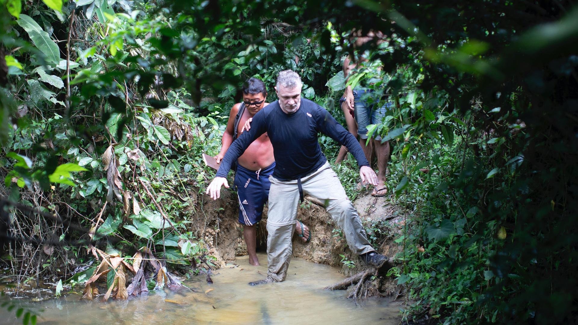 people walking through mud in a village in Brazil
