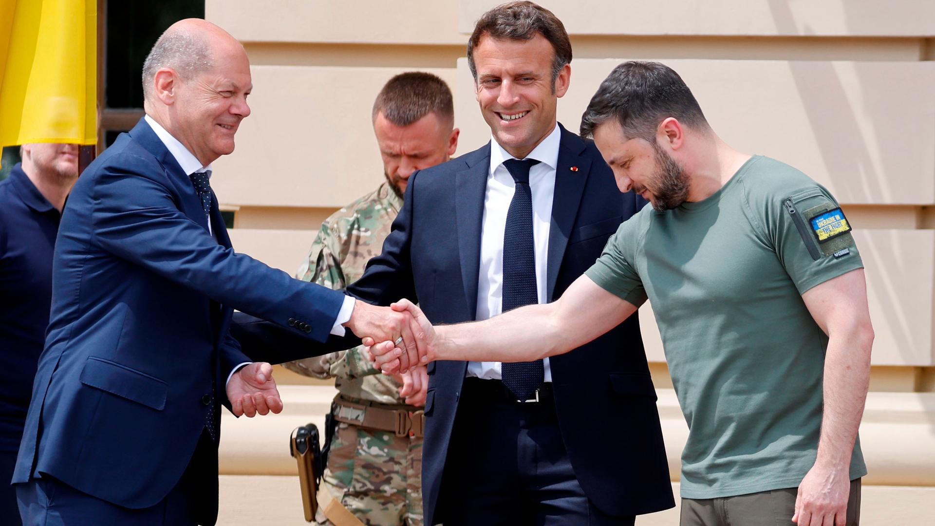 German Chancellor Olaf Scholz, left, shakes hands with Ukrainian President Volodymyr Zelenskiy, as French President Emmanuel Macron, center, looks on before a meeting in Kyiv, Thursday, June 16, 2022. 
