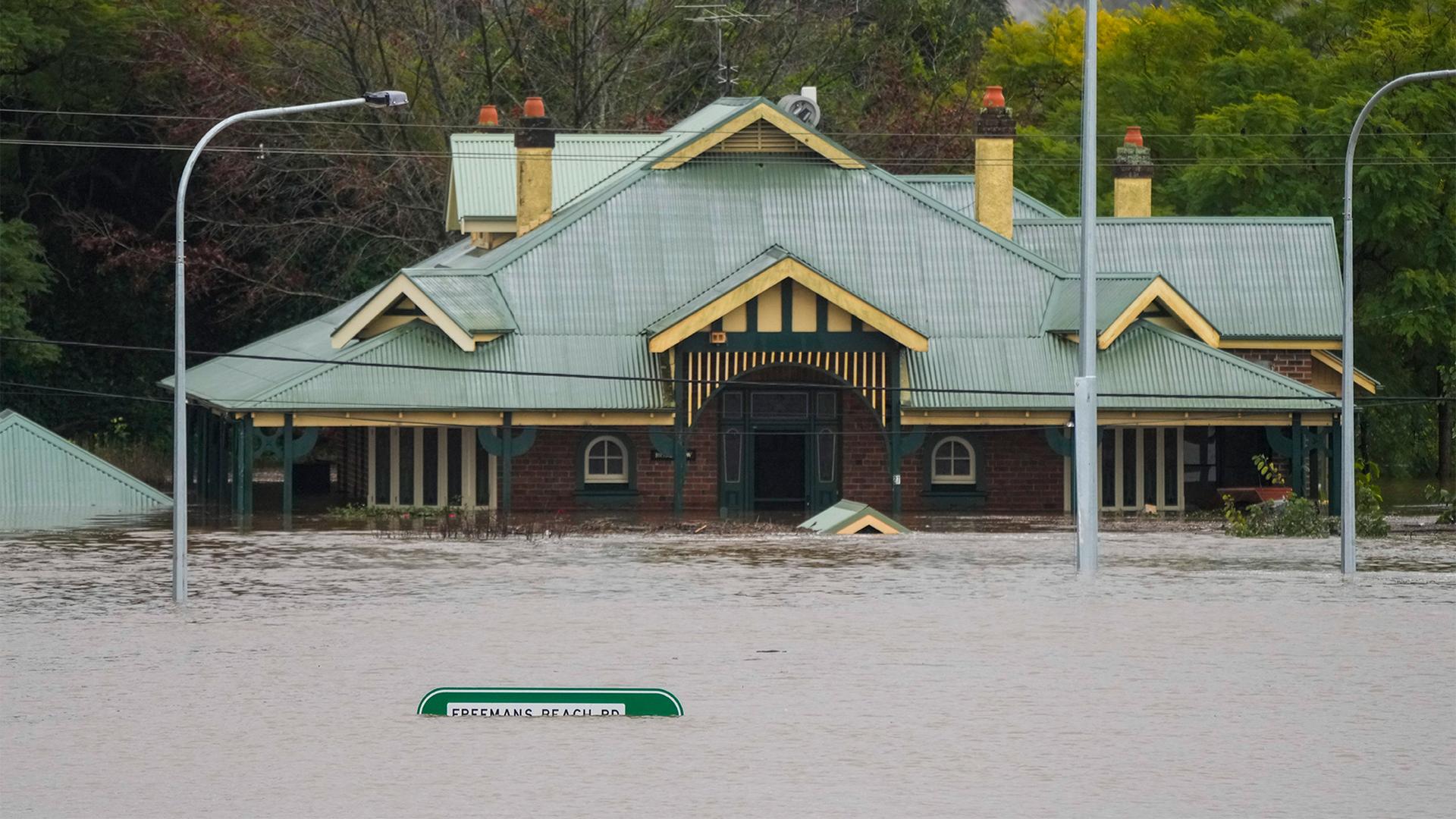 A building is inundated with water on the far side of the Windsor Bridge at Windsor on the outskirts of Sydney, Australia