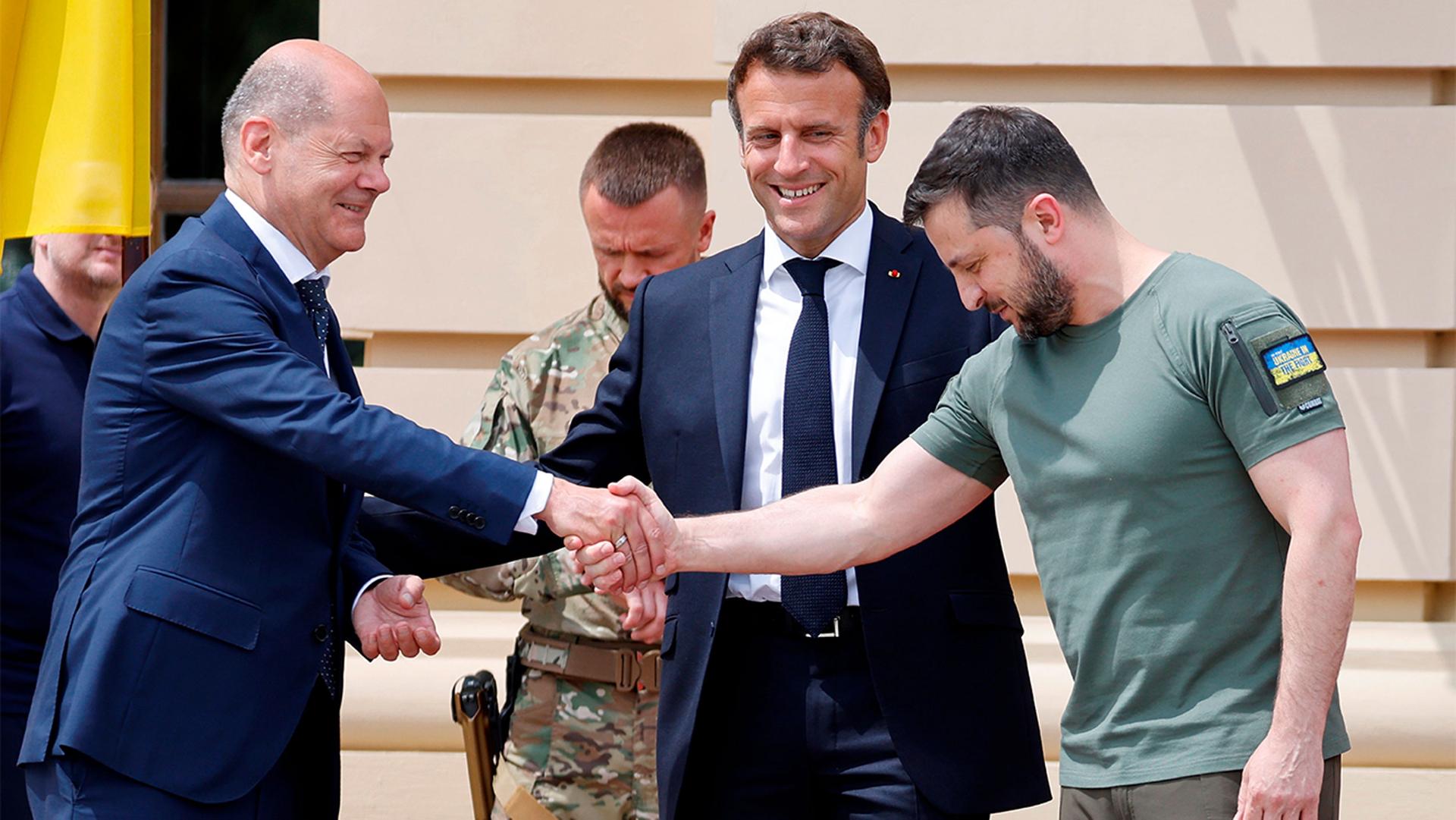 German Chancellor Olaf Scholz, left, shakes hands with Ukrainian President Volodymyr Zelenskyy, as French President Emmanuel Macron, looks on before a meeting in Kyiv, Ukraine