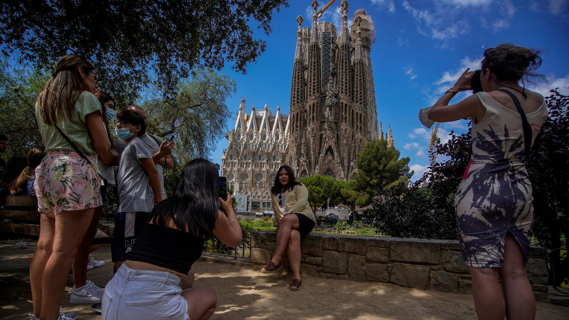 People take pictures in front of Sagrada Familia Basilica designed by architect Antoni Gaudi in Barcelona, Spain, Friday, July 9, 2021. 