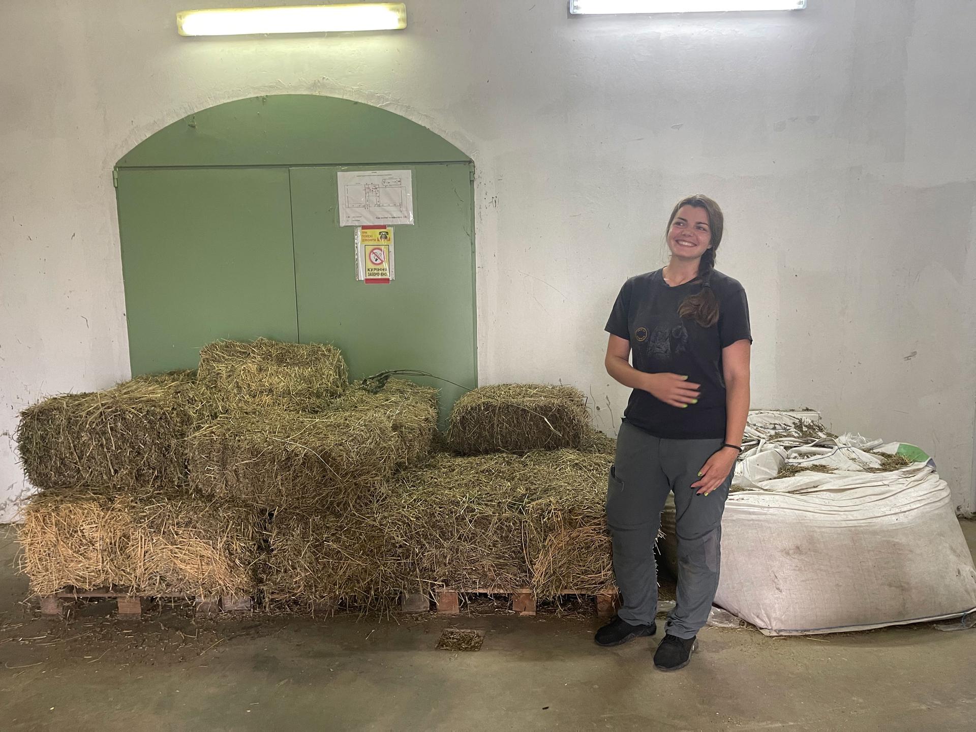 Zoo XII Months veterinarian Alina Malynka poses in front of the bails of hay where she slept when Russians occupied the zoo for over a month at the end of February. She was one of the six zoo staff members trapped inside for over 35 days.