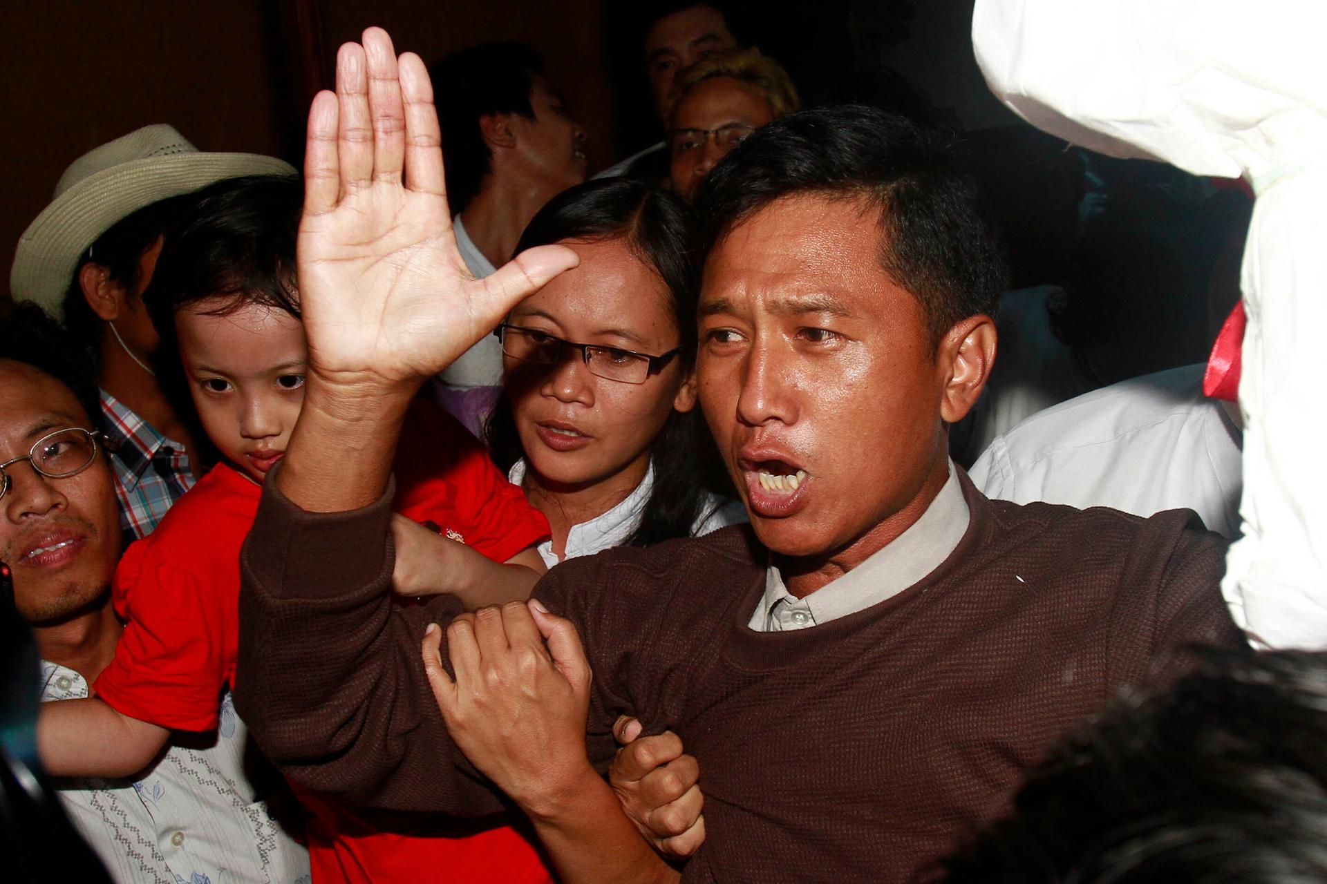 Kyaw Min Yu, a pro-democracy activist talks to journalists as he arrives at Yangon airport welcomed by his wife Nilar Thein, background, also an activist and his daughter after being released from a prison on Jan. 13, 2012, in Yangon.