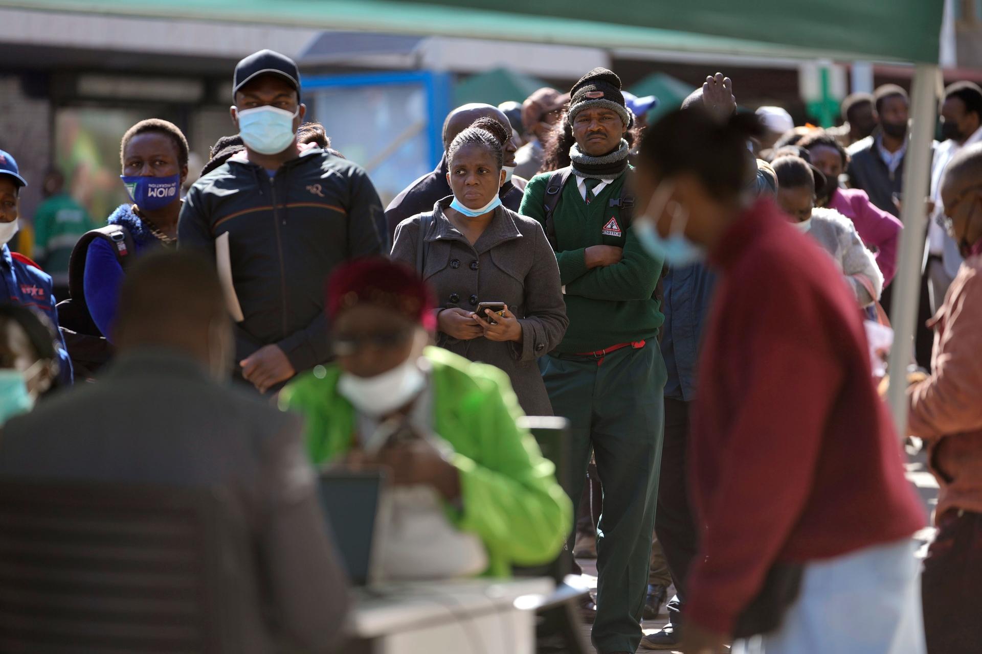 People stand in a bank queue in Harare, Monday, July 25, 2022.
