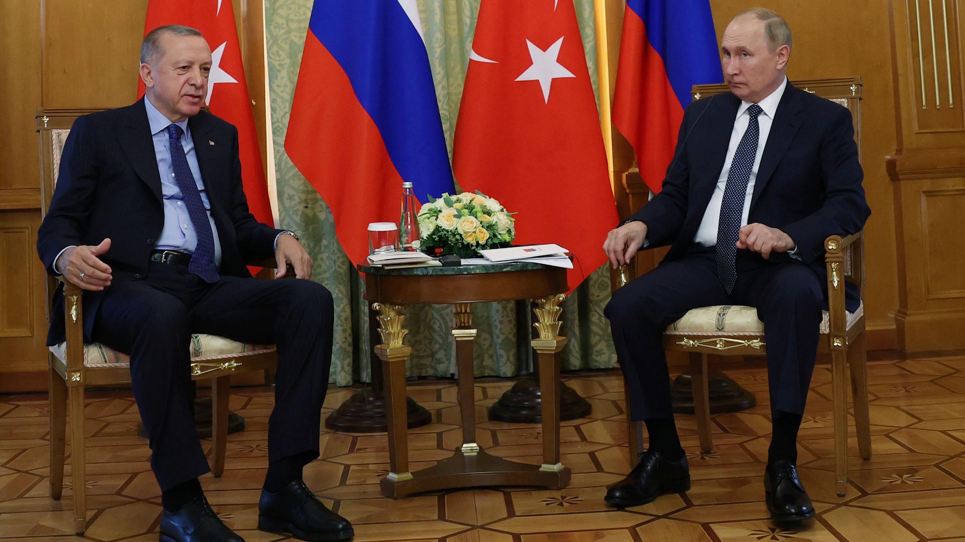 In this handout photo provided by the Turkish Presidency, Turkish President Recep Tayyip Erdogan, left, and Russian President Vladimir Putin speak their meeting at the Rus sanatorium in the Black Sea resort of Sochi, Russia, Friday, Aug. 5, 2022. 