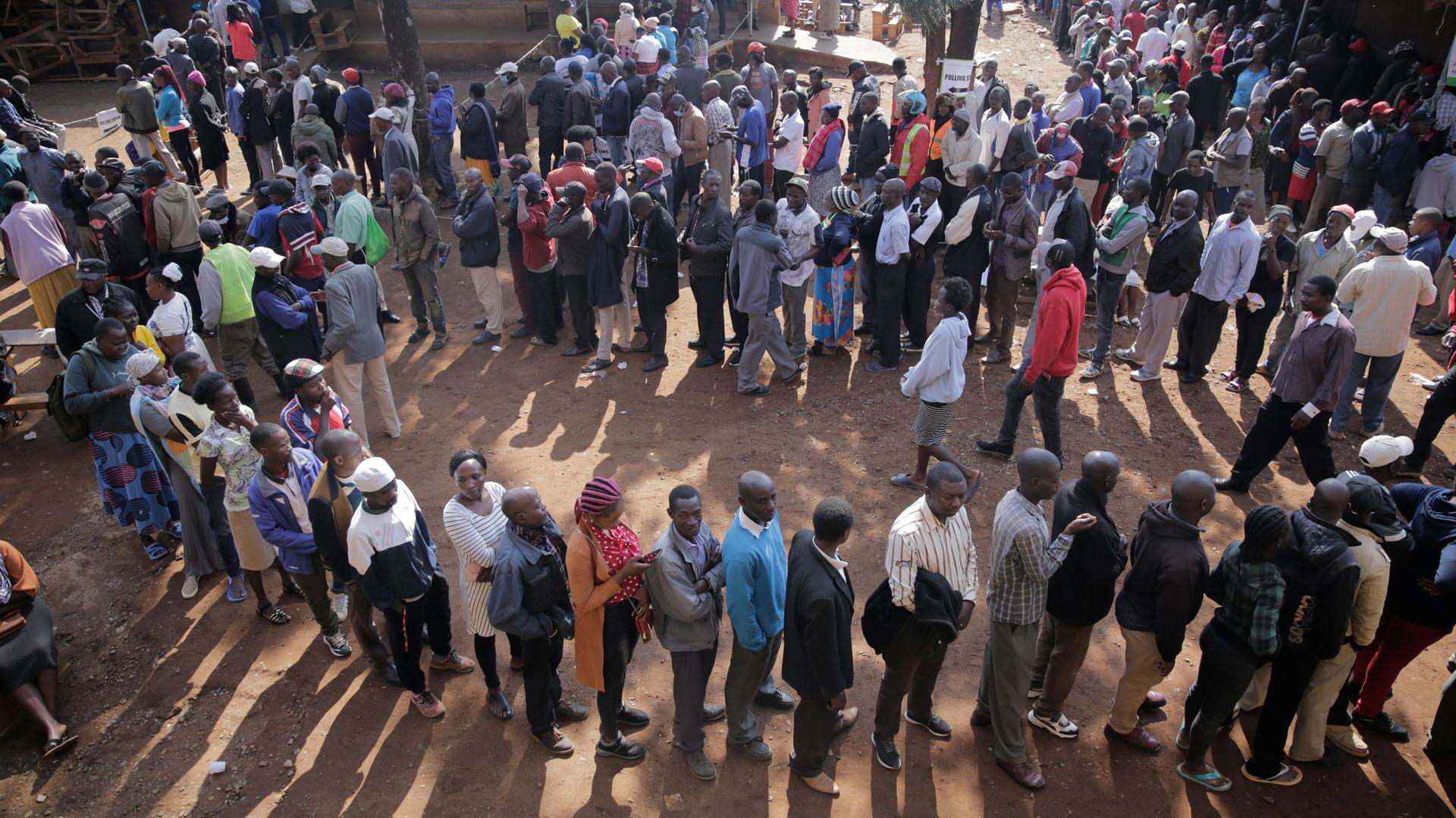 People line up to cast their vote in Kenya's general election in Eldoret, Kenya, Tuesday Aug. 9, 2022. Kenyans are voting to choose between opposition leader Raila Odinga Deputy President William Ruto to succeed President Uhuru Kenyatta after a decade in 