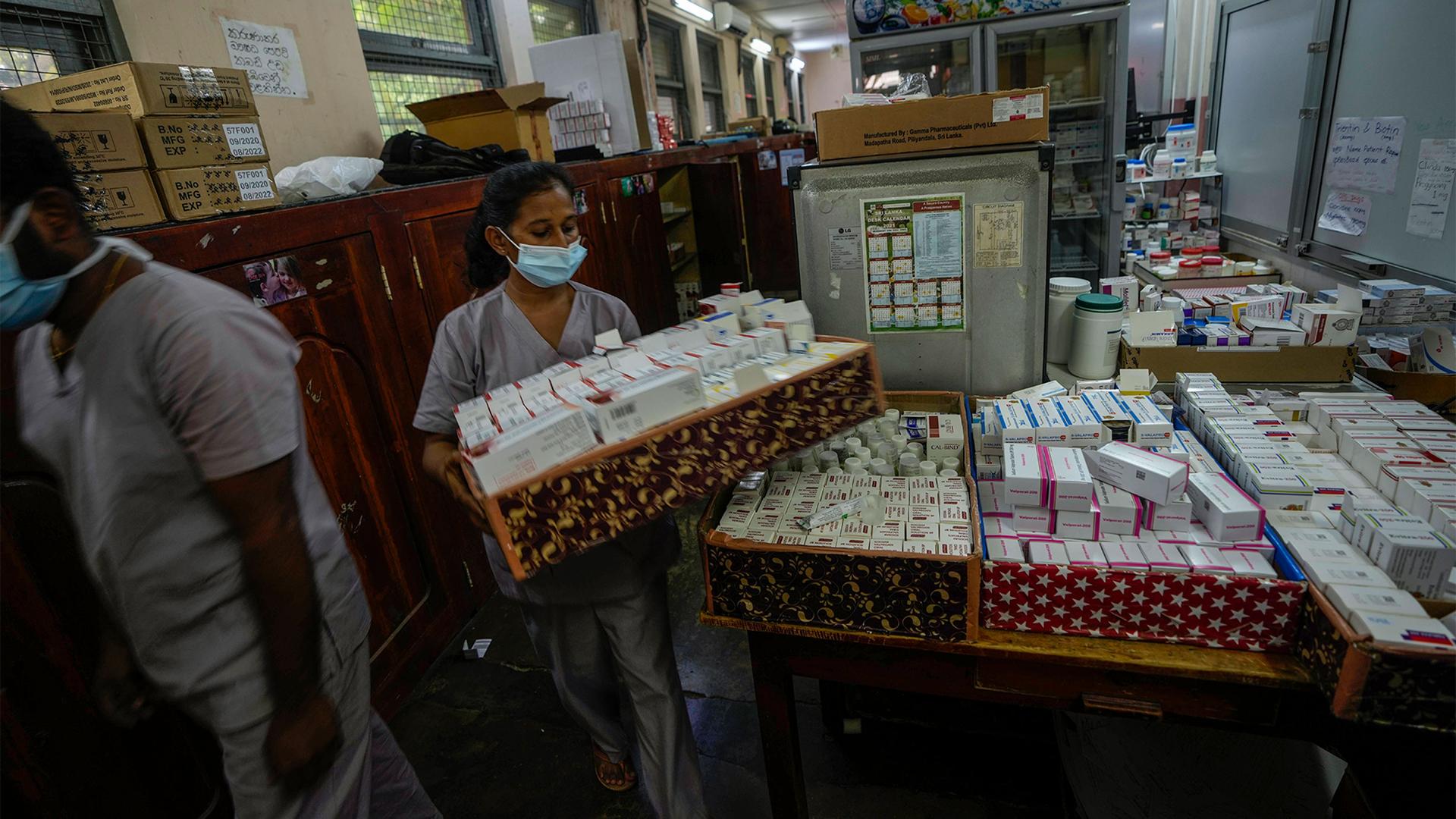 A hospital worker carries a tray of medicine at a government-run hospital in Colombo, Sri Lanka