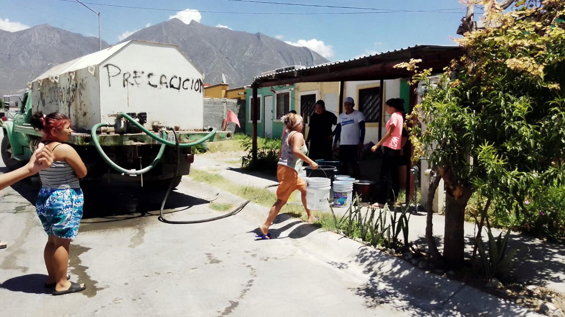 People in the Colonia Valle de Lincoln, in the area of Poniente, Monterrey, line up to get water from the delivery truck.