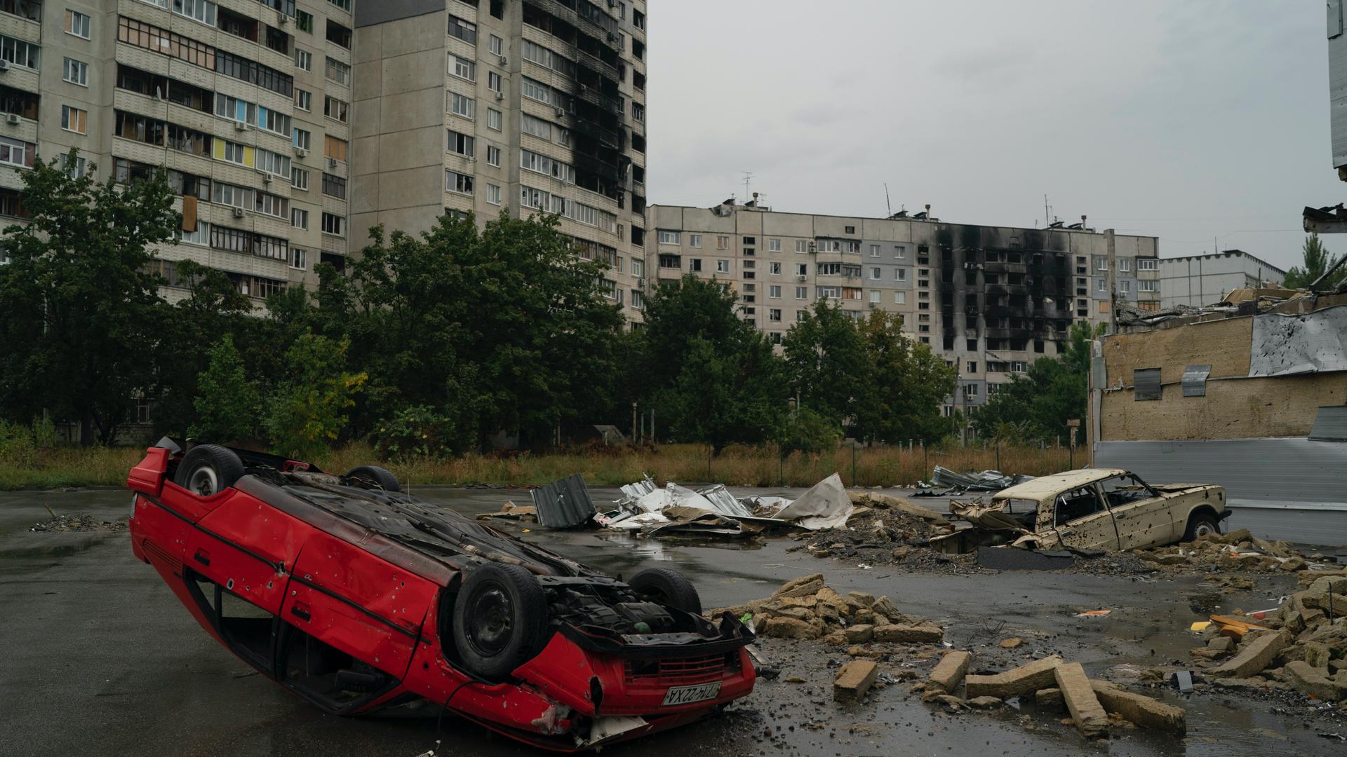 destroyed buildings and overturned car 