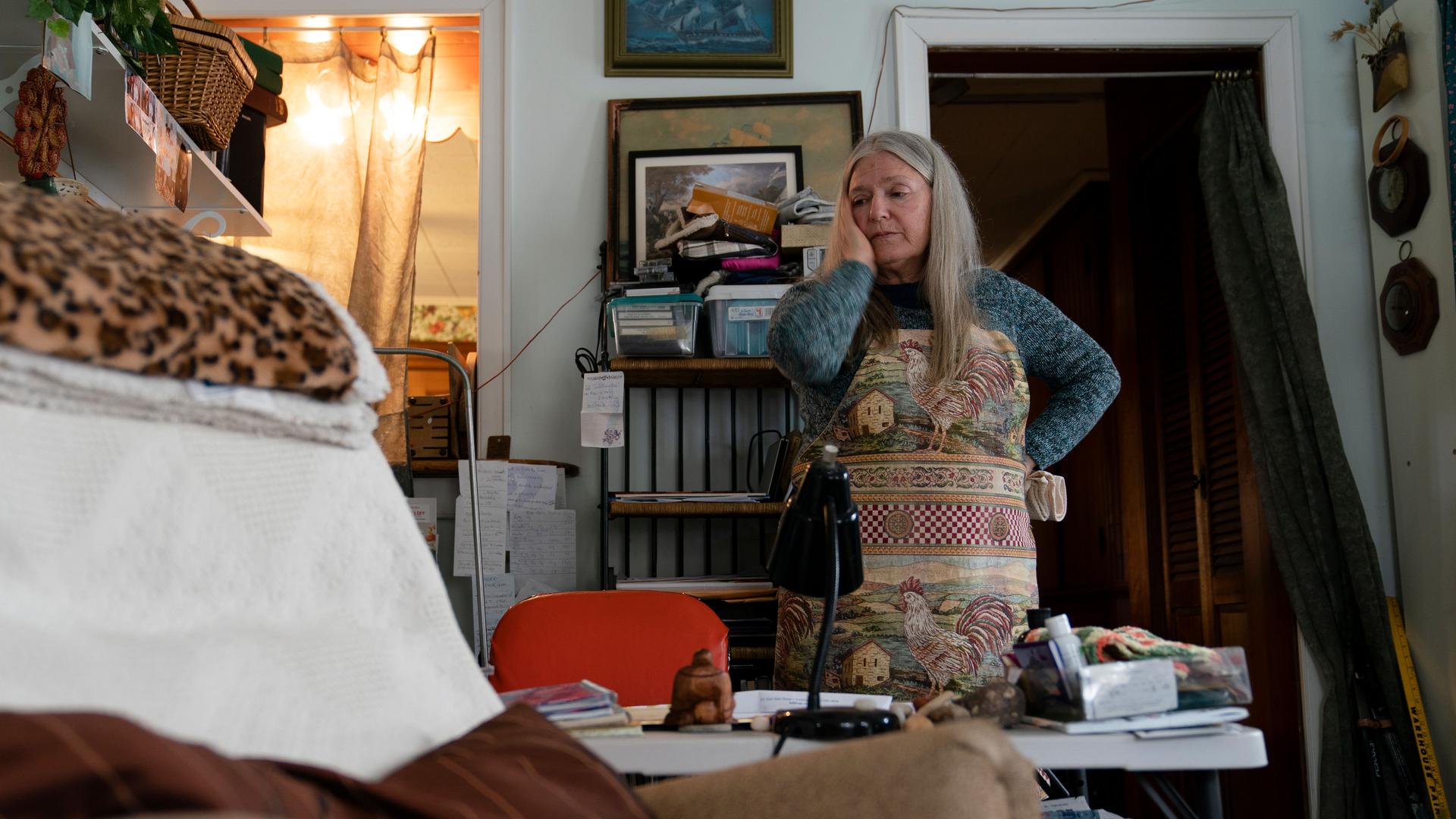 Nancy Rose, who contracted COVID-19 in 2021 and continues to exhibit long-haul symptoms including brain fog and memory difficulties, pauses while organizing her desk space, on Jan. 25, 2022, in Port Jefferson, New York.