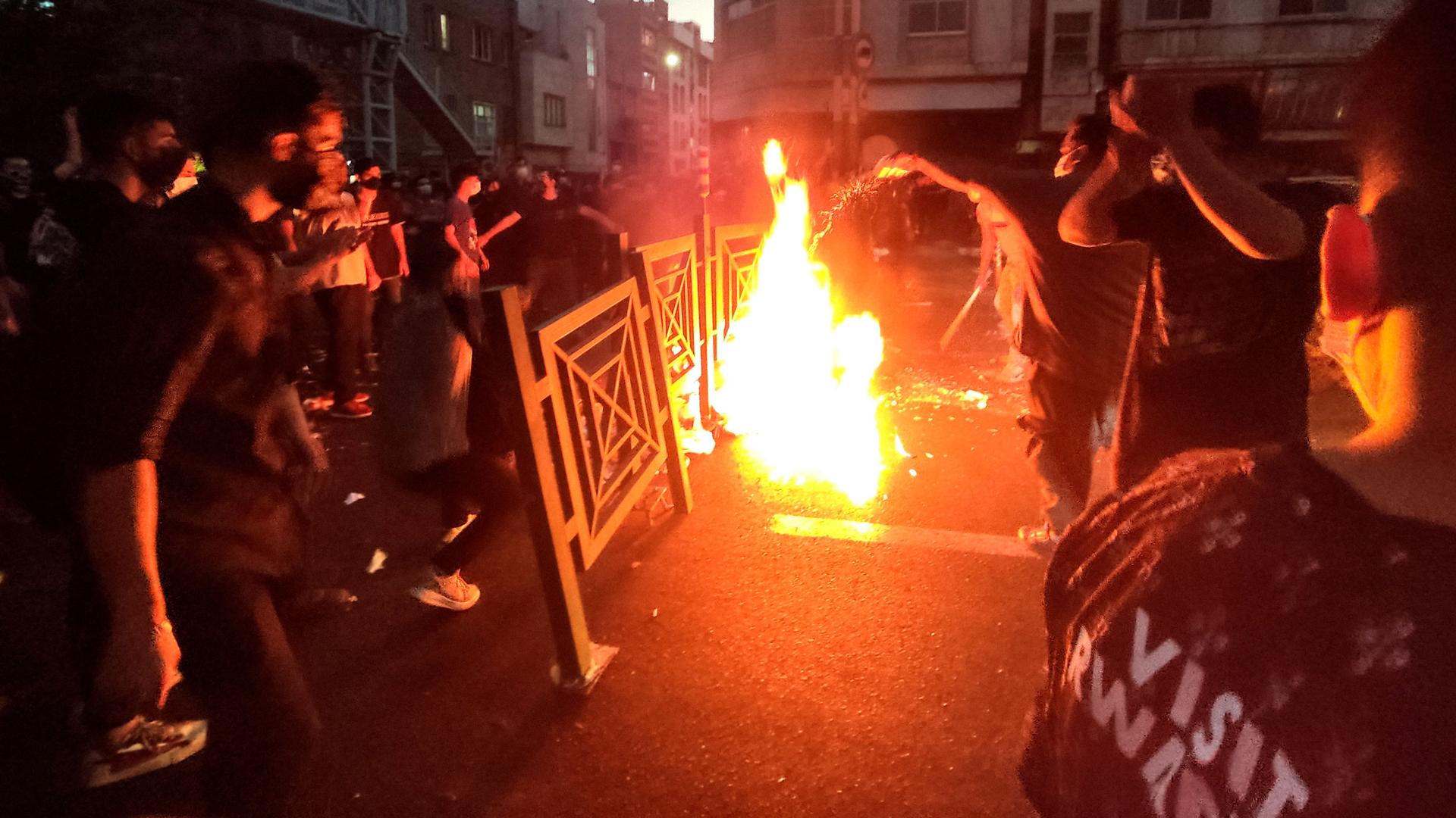 In this Wednesday, Sept. 21, 2022, photo taken by an individual not employed by the Associated Press and obtained by the AP outside Iran, protesters make fire and block the street during a protest over the death of a woman who was detained by the morality