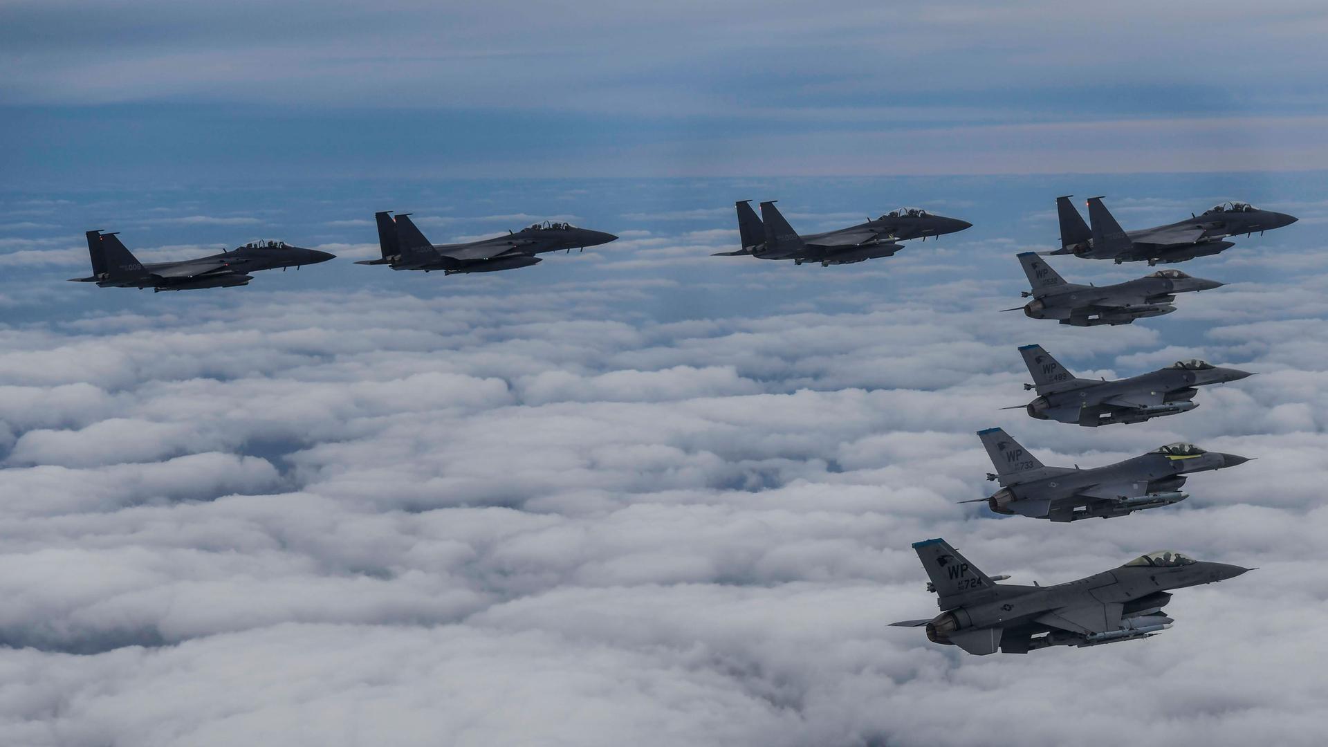 In this photo provided by South Korea Defense Ministry, South Korean Air Force's F15K fighter jets and US Air Force's F-16 fighter jets, fly in formation during a joint drill in an undisclosed location in South Korea, Tuesday, Oct. 4, 2022. 