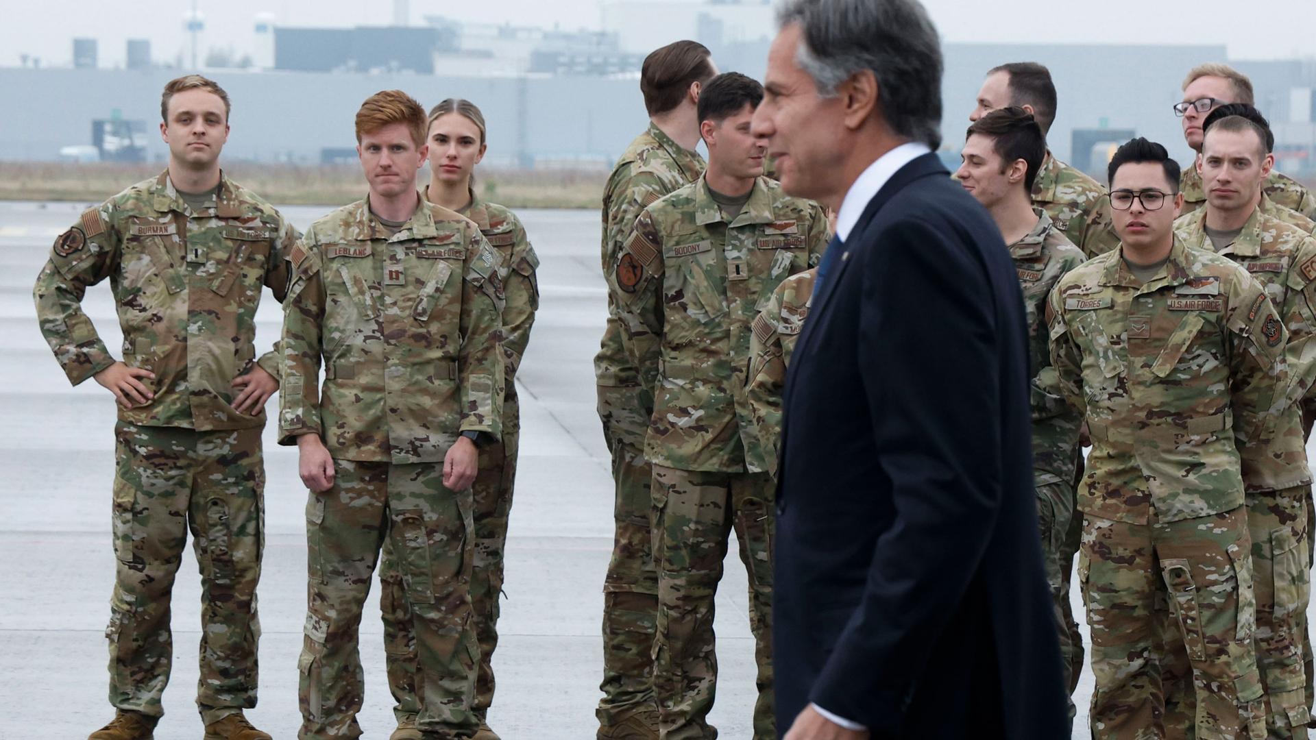 American military personnel wait to greet US Secretary of State Antony Blinken before he boards a plane to travel to Brussels.