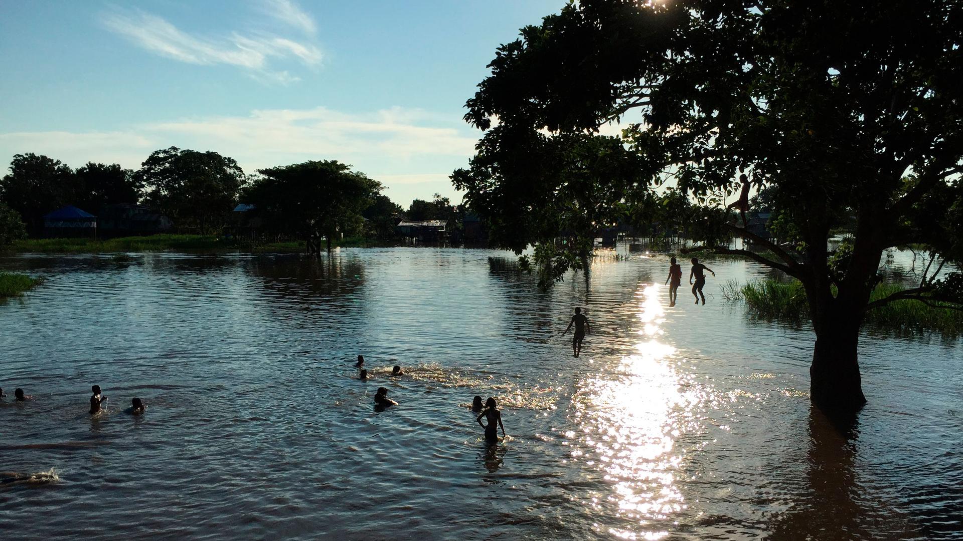 Children play in a flooded area of Leticia, Colombia, Feb. 14, 2017, located by the Amazon River, on the border with Brazil and Peru. 