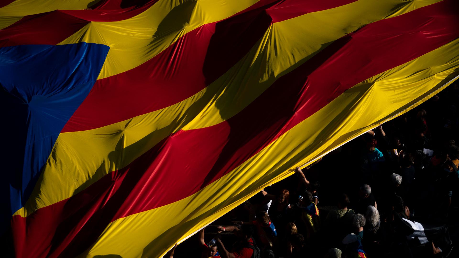 Protesters hold esteladas or independence flags as they take part in a demonstration during the Catalan National Day in Barcelona, Spain, Sunday, Sept. 11, 2022. 