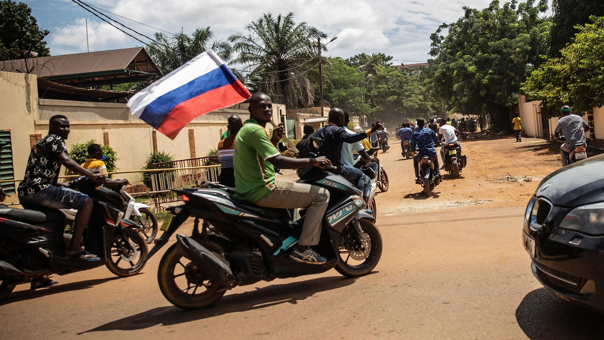 Supporters of Capt. Ibrahim Traore parade waving a Russian flag in the streets of Ouagadougou, Burkina Faso, Oct. 2, 2022. 