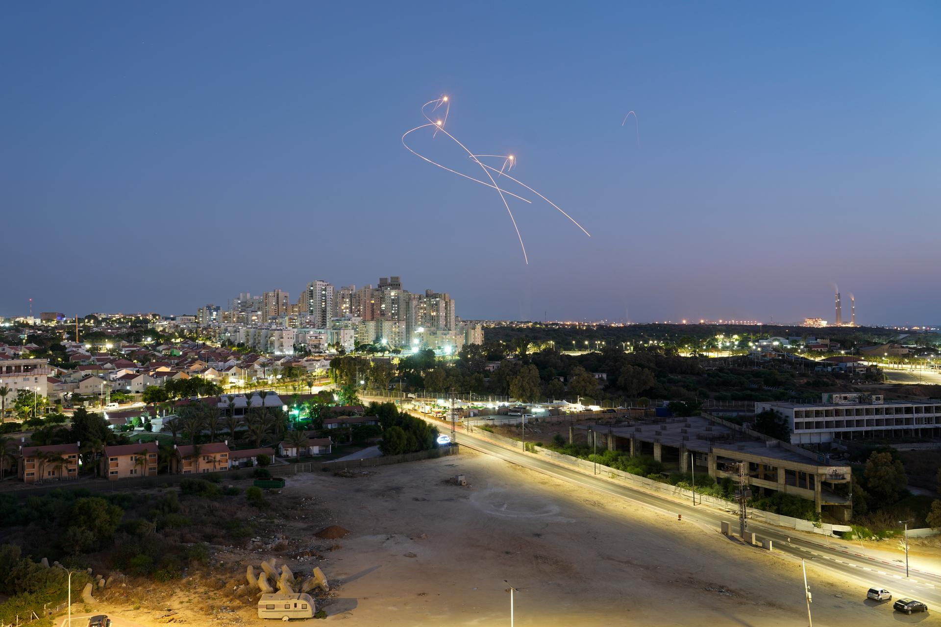 A defense system intercepting missiles in Israel at night.
