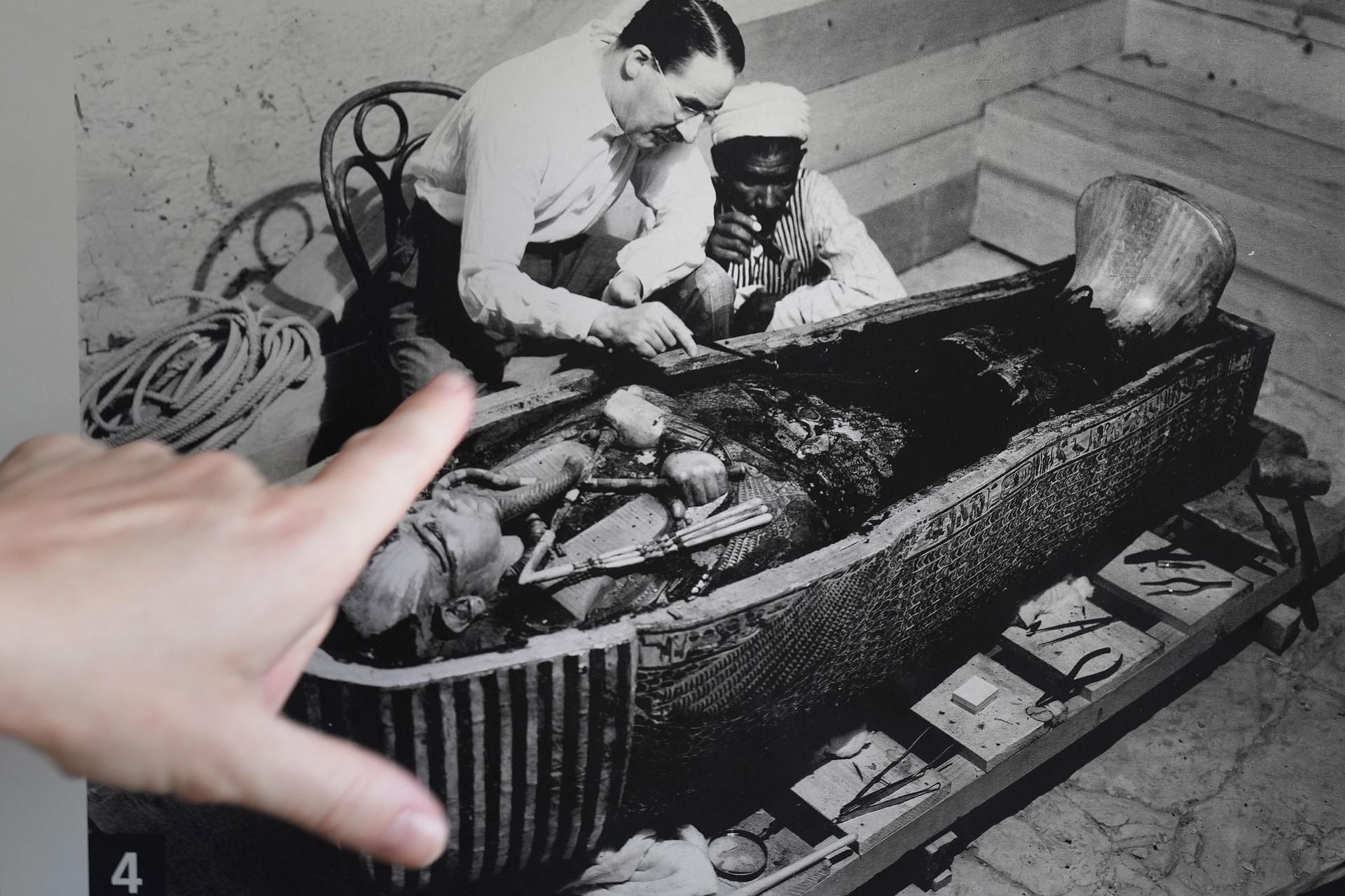 A tourist talks in front of a picture showing British archaeologist Howard Carter in front of the sarcophagus of King Tutankhamun at his tomb the Valley of the Kings in Luxor, Egypt, Friday, Nov. 4, 2022. 