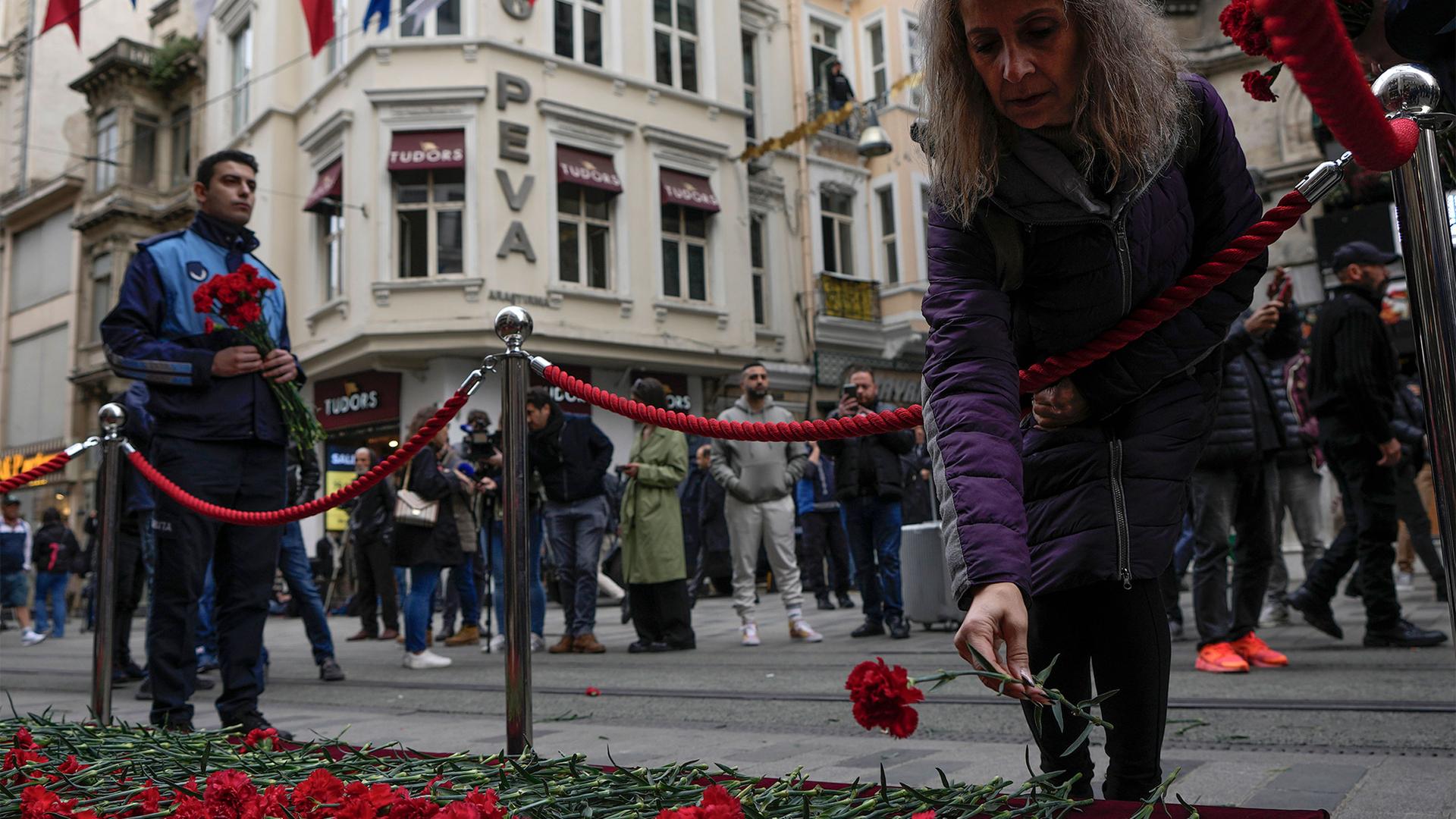 People put flowers over a memorial placed on the spot of Sunday's explosion on Istanbul's popular pedestrian Istiklal Avenue in Istanbul, Nov. 14, 2022.