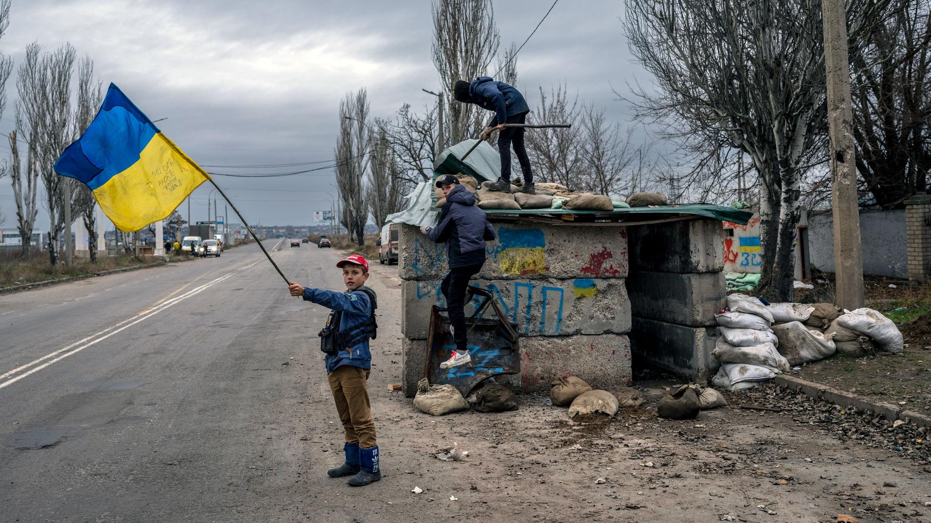 Ukrainian children play at an abandoned checkpoint in Kherson, southern Ukraine, Wednesday, Nov. 23, 2022. 