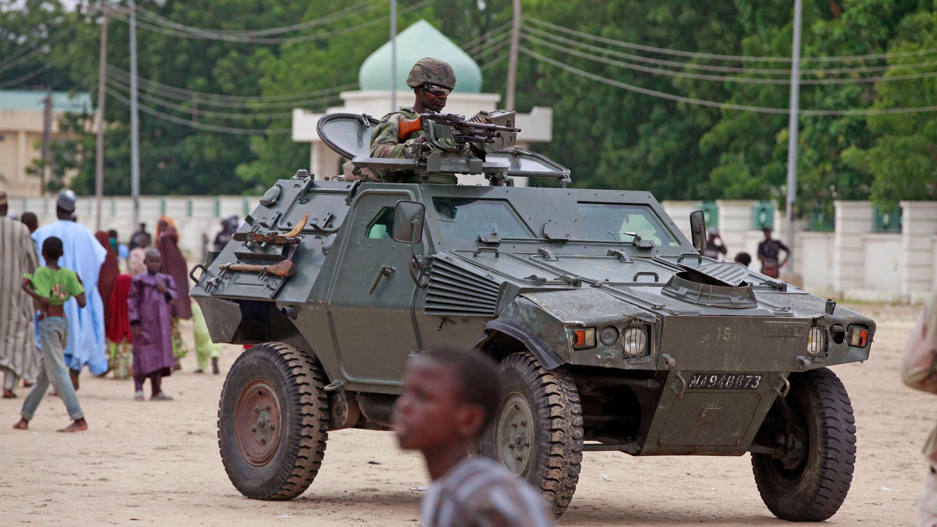 In this file photo taken Thursday, Aug. 8, 2013, a Nigerian soldier patrols in an armored car, during Eid al-Fitr celebrations, in Maiduguri, Nigeria. 
