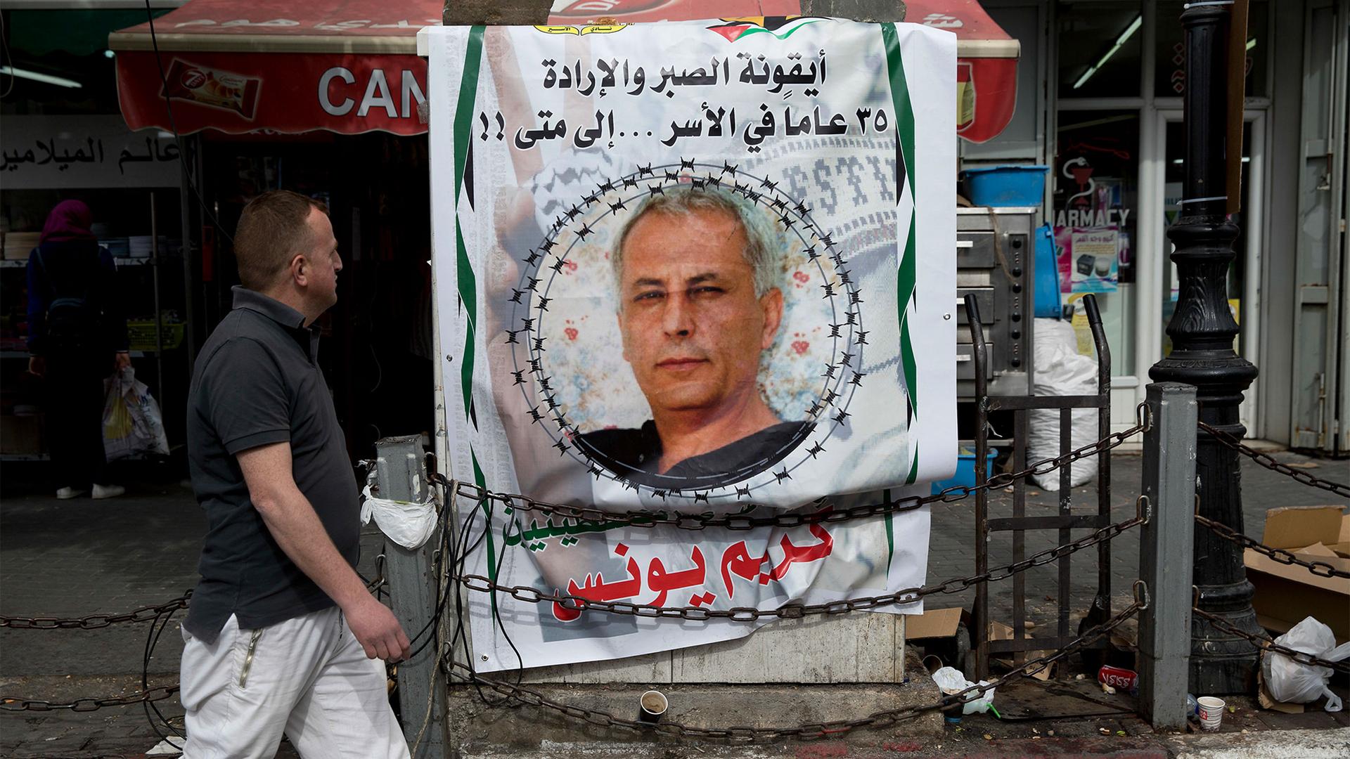A banner with a picture of a Palestinian prisoner in an Israeli jail reads in Arabic "Karim Younis, the icon of patience and will, 35 years in captivity, for how long," in the West Bank city of Ramallah