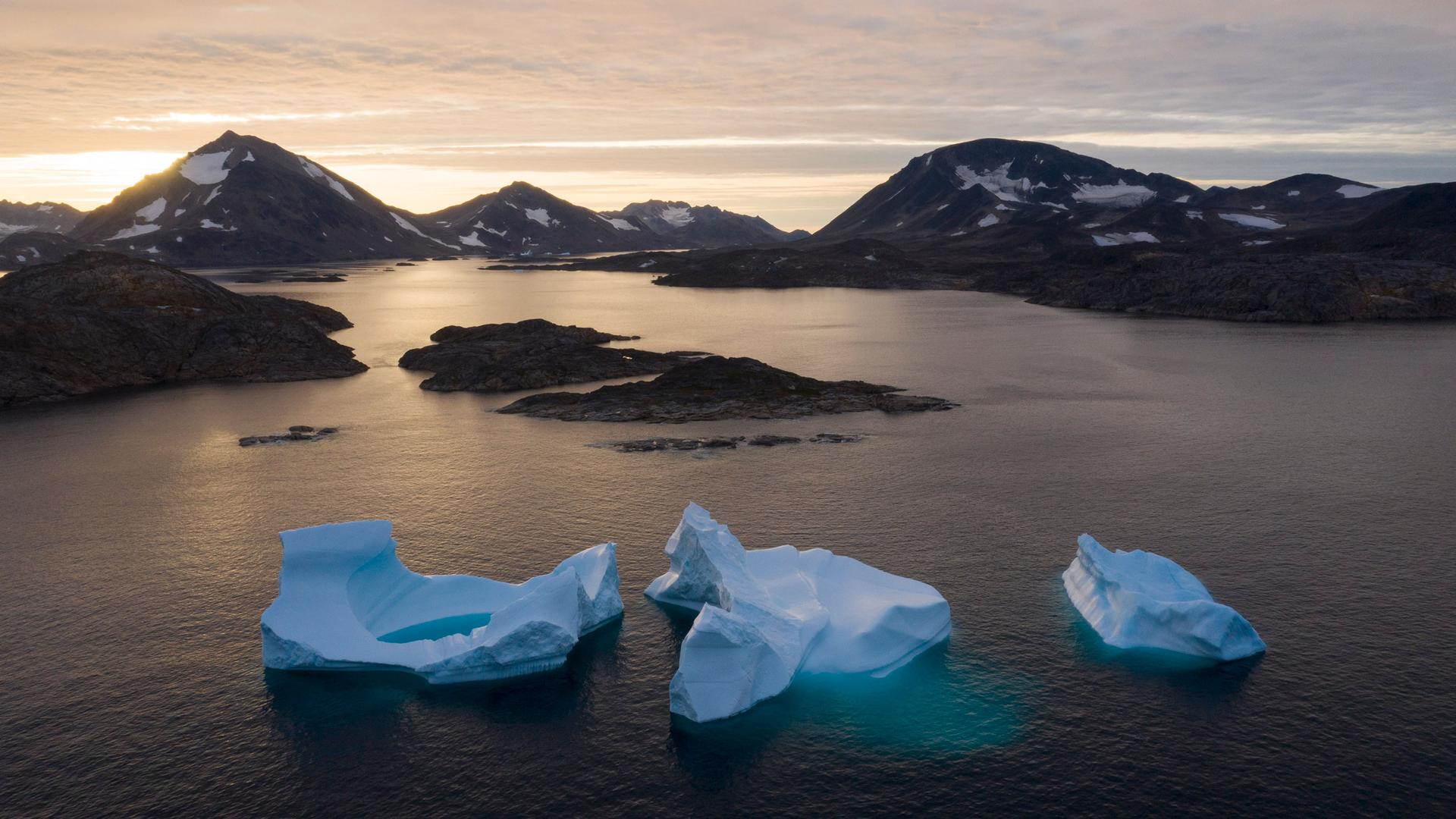 Large icebergs float away as the sun rises near Kulusuk, Greenland, Aug. 16, 2019. 