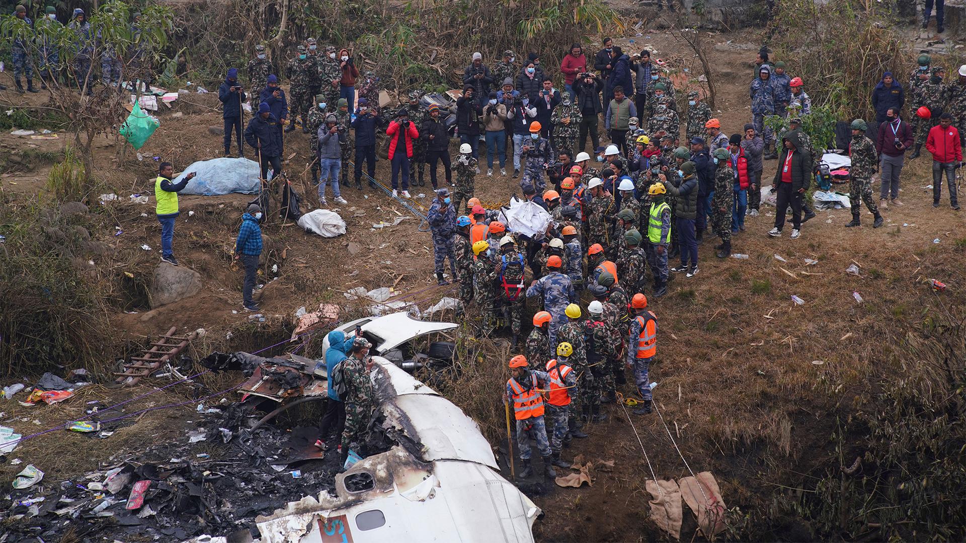 Rescuers scour the crash site in the wreckage of a passenger plane in Pokhara, Nepal, Jan.16, 2023.