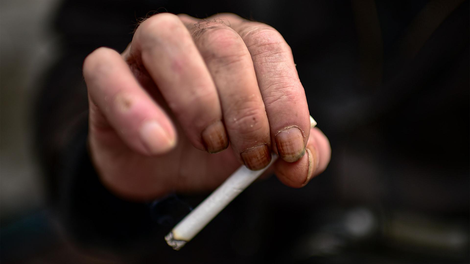 Antonio Trujillo holds a cigarette while resting on a bench, in Pamplona, northern Spain