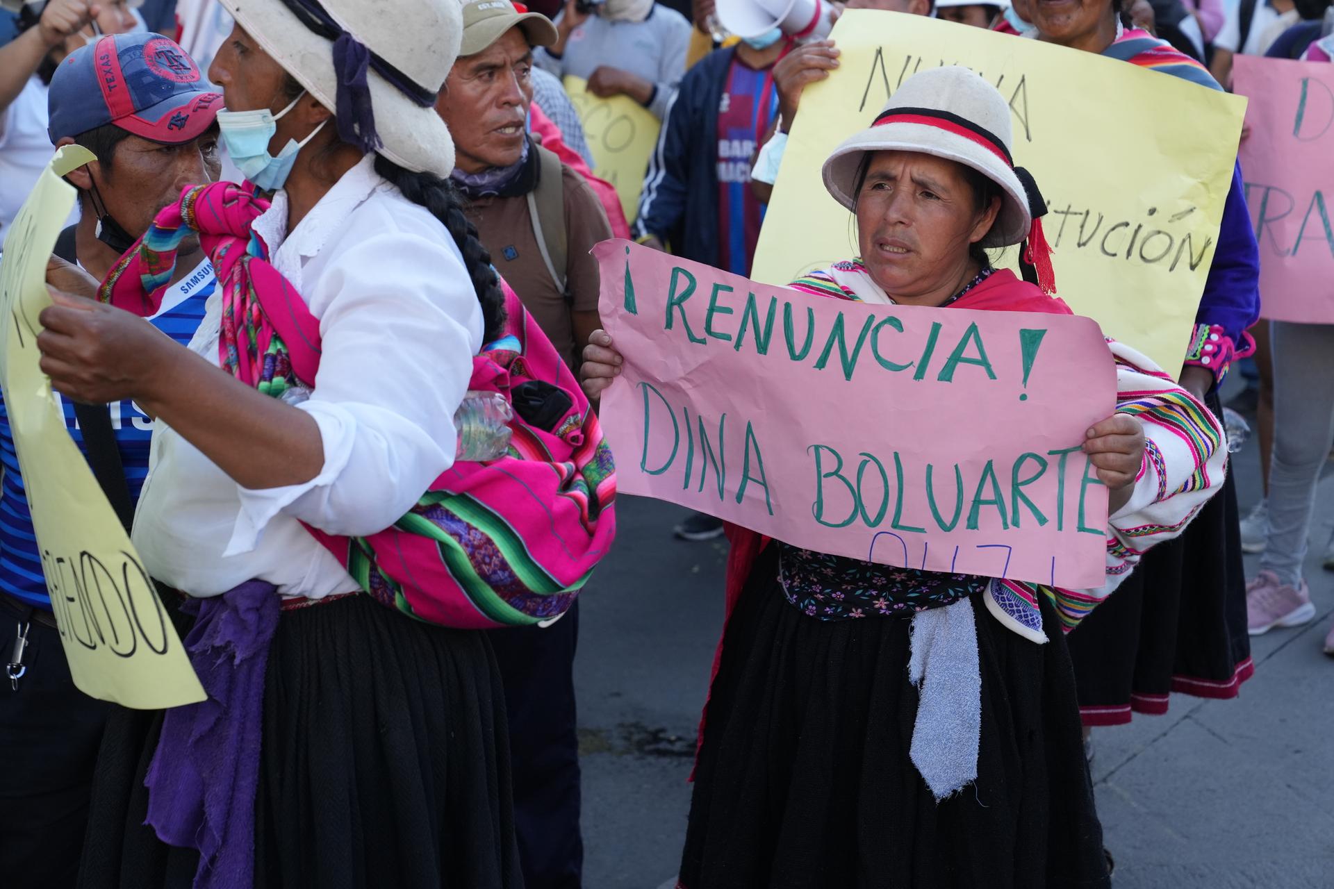 A woman holds up a sign during a protest in Lima, Peru