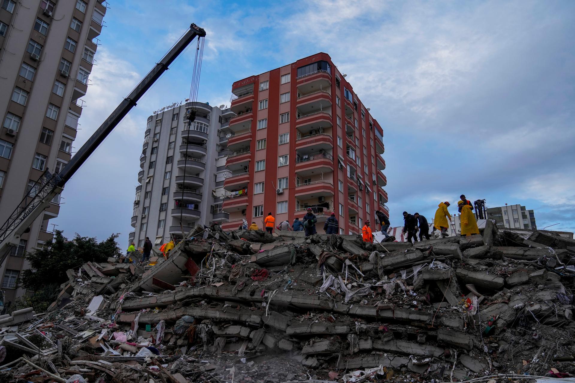 Emergency teams search for people in a destroyed building in Adana, Turkey, after a powerful quake knocked down multiple buildings, Feb. 6, 2023.