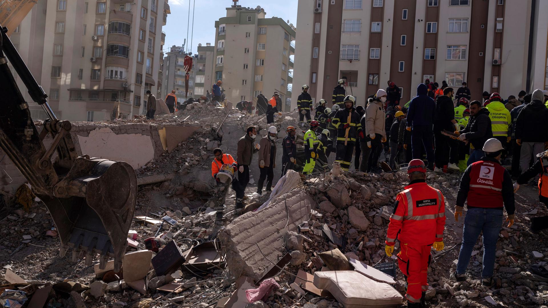 Firefighters and rescue teams search for people in a destroyed building, in Adana, southern Turkey, Wednesday, Feb. 8, 2023. 