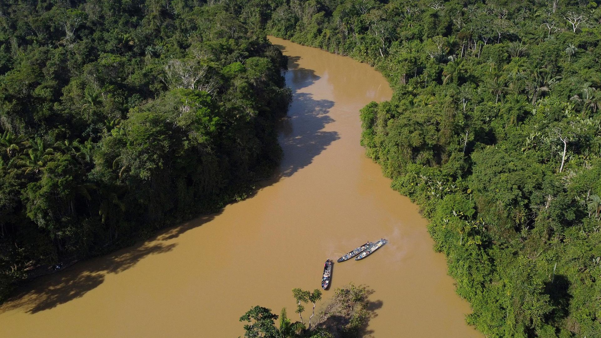 Boats carrying mining supplies move along the Uraricoera River in Alto Alegre, Roraima state, Brazil, as some miners leave Yanomami Indigenous territory ahead of expected operations against illegal mining, Tuesday, Feb. 7, 2023. 