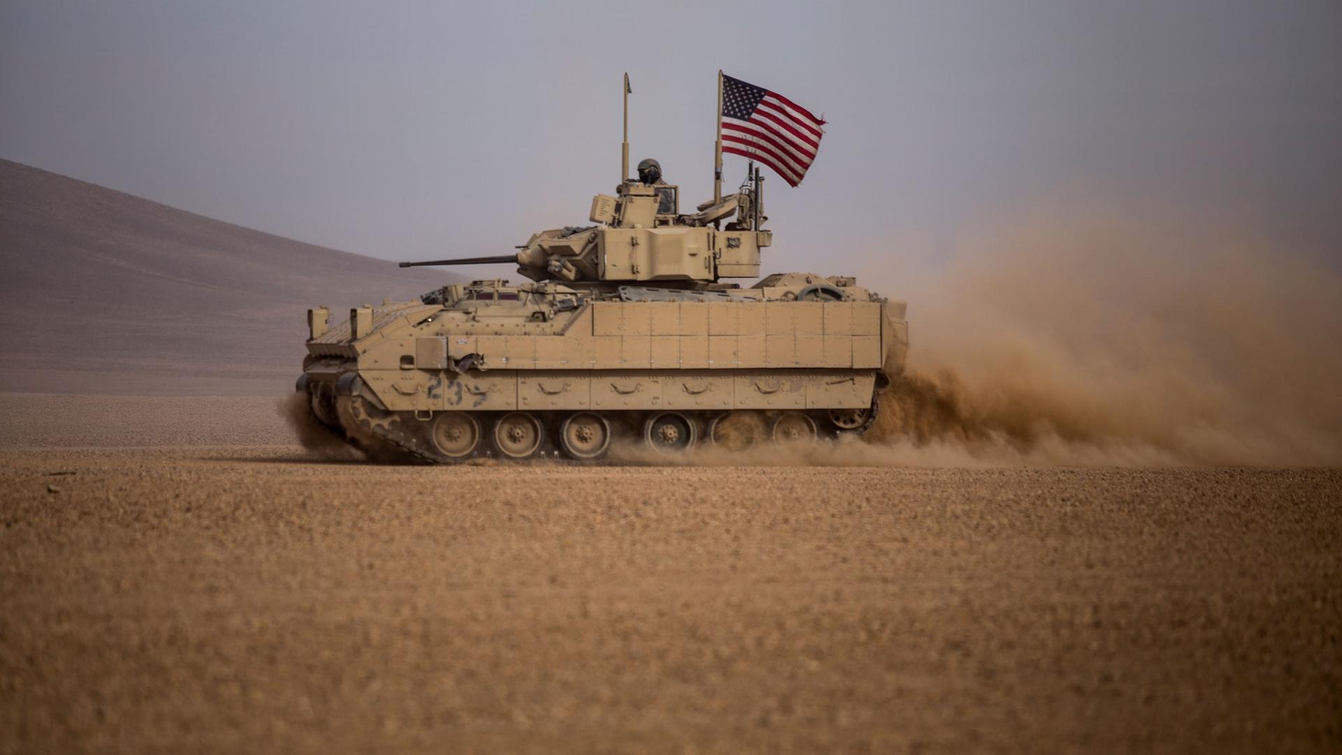 American soldiers drive a Bradley fighting vehicle during a joint exercise with Syrian Democratic Forces at the countryside of Deir Ezzor in northeastern Syria, Dec. 8, 2021. 