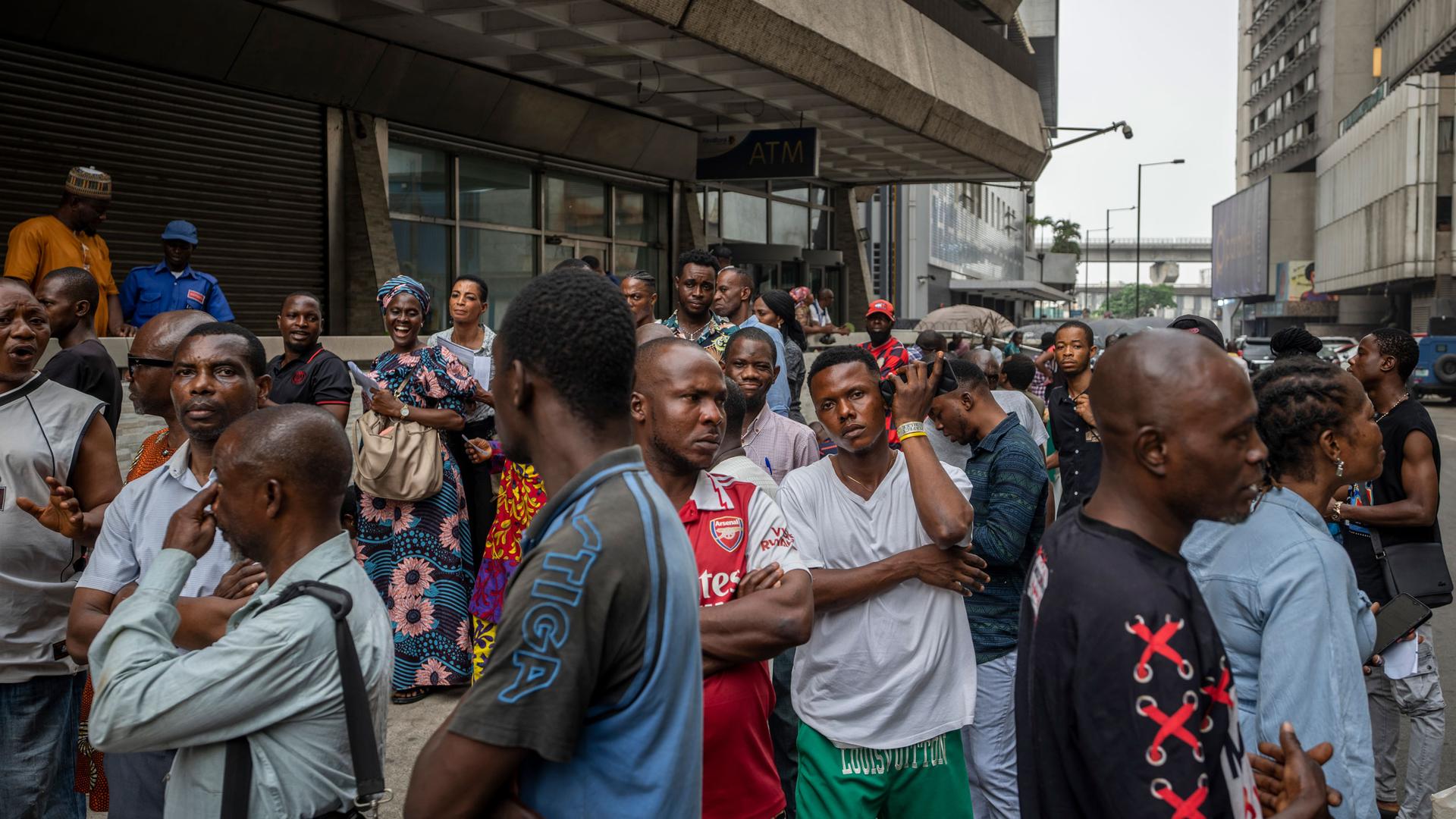 Customers who had waited for many hours stand outside a bank in the slim hope of being able to withdraw some cash, in Lagos, Nigeria Thursday, Feb. 23, 2023. 