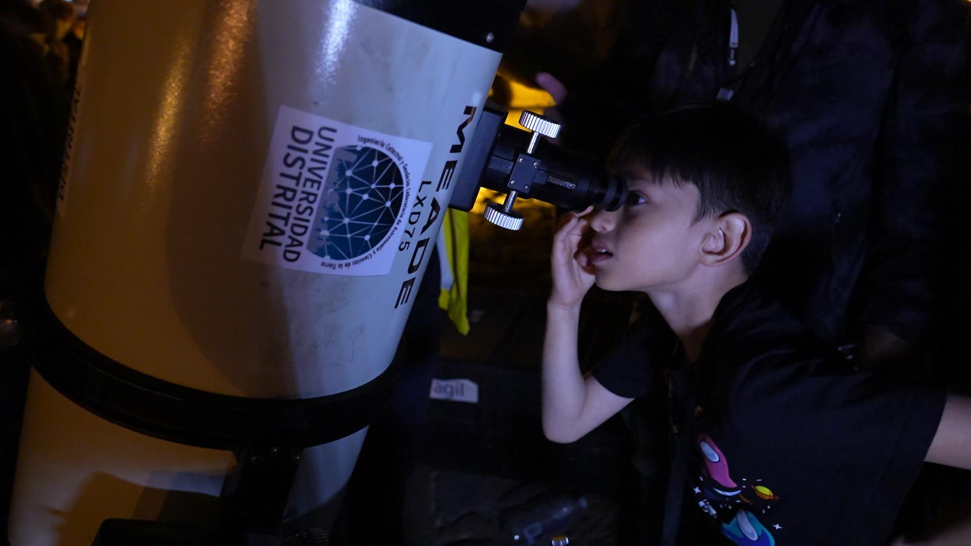 Third grader Andres Camilo Morales looks at the Orion nebula through a telescope placed in Villa de Leyva's central square. 