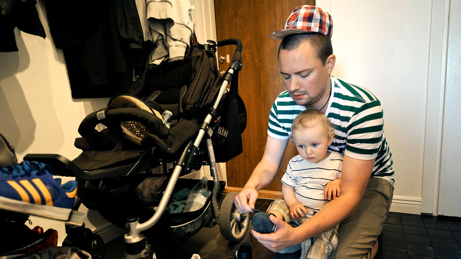 In this Wednesday, June 29, 2011, photo, Henrik Holgersson puts a shoe on his son.