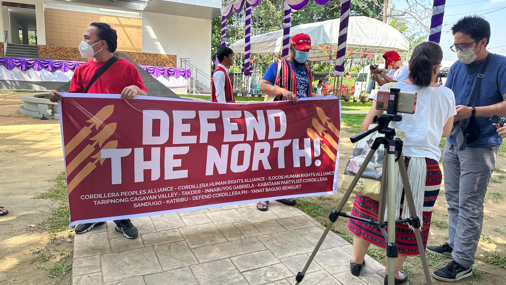 Protesters hold posters calling for protection of Indigenous lands amid growing number of development projects in the Philippines.