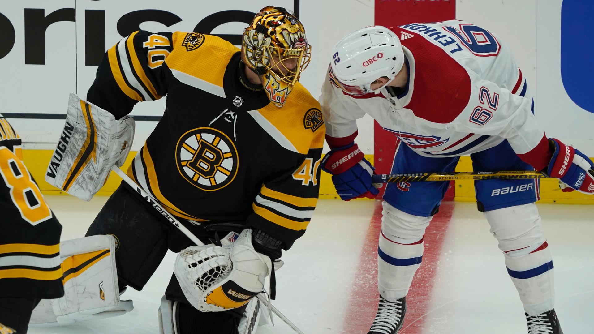 Two players from Boston bruins and Montreal Canadiens hockey teams talk to each other on the ice