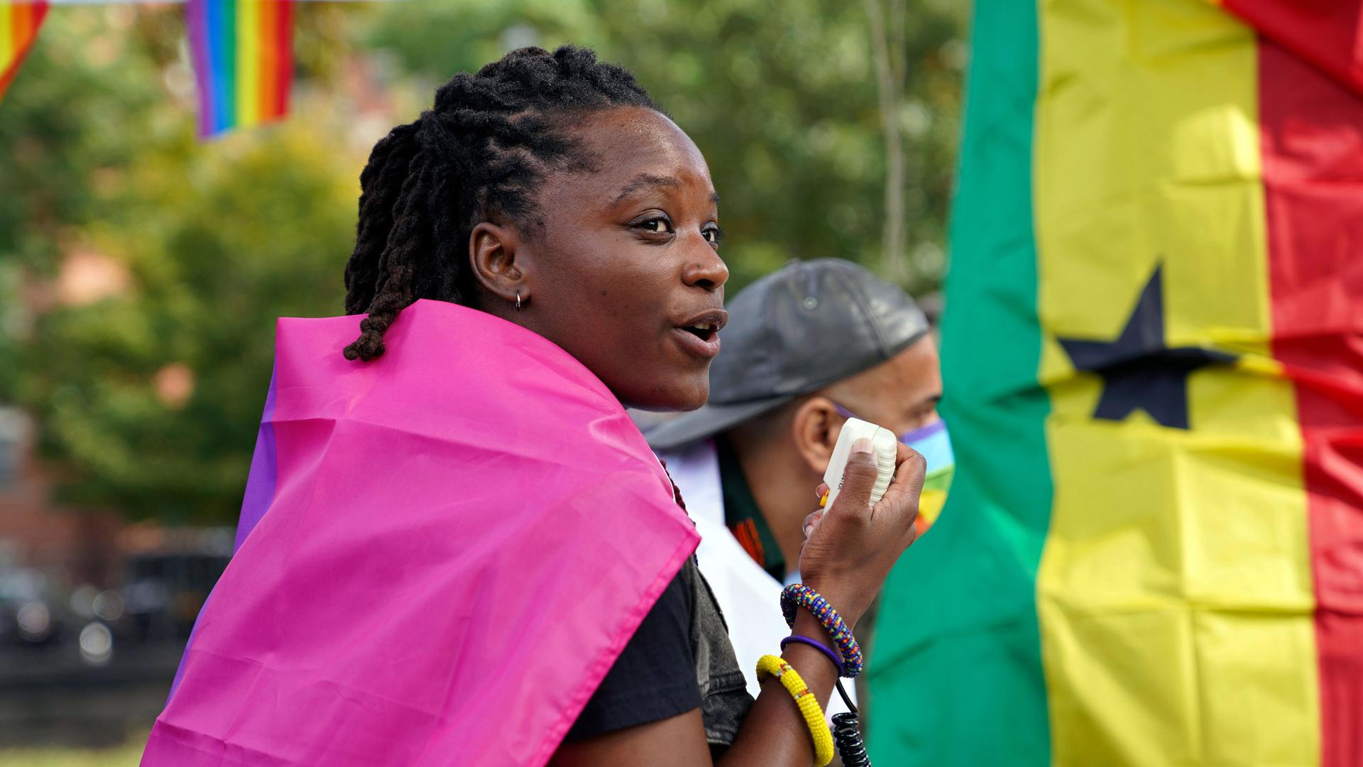 Ghanian activist at a rally near a Ghanaian flag. 