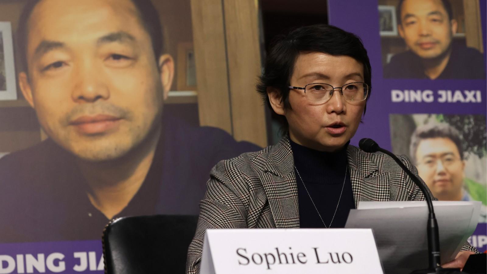 As a photo of her husband Chinese human rights activist Ding Jiaxi is on display in the background, Sophie Luo testifies during a hearing before The Congressional-Executive Commission on China (CECC) at Dirksen Senate Office Building on Capitol Hill on Fe