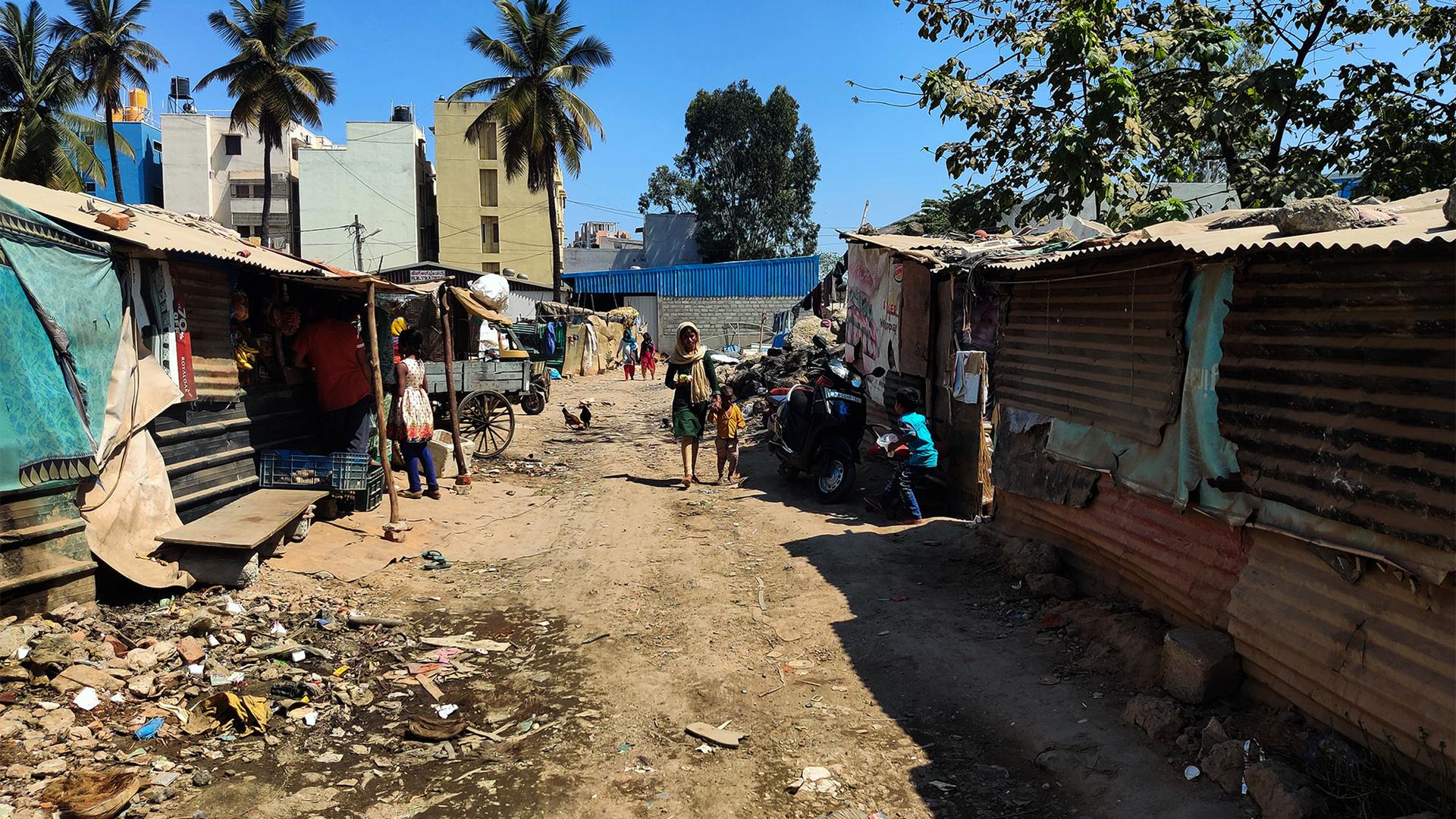 People walk through an informal settlement for trash segregators in Bangalore, India.